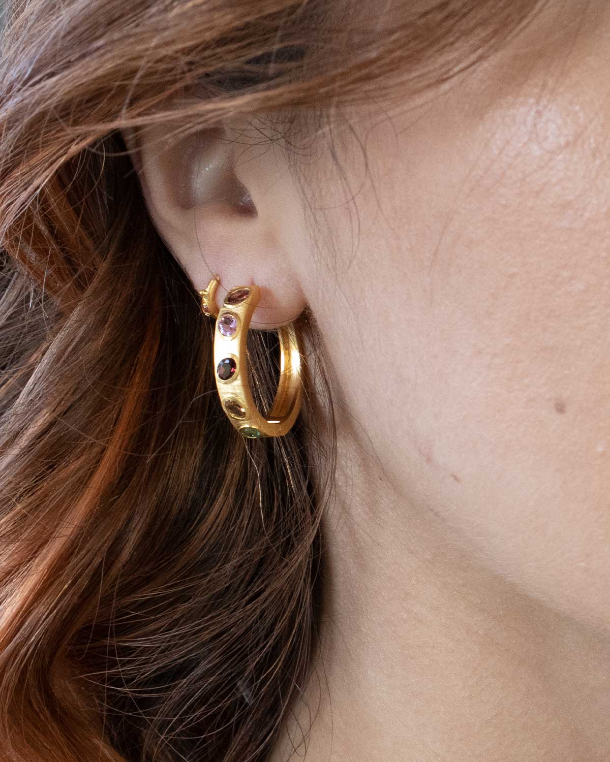 a model wearing gold jewellery tourmaline hoops