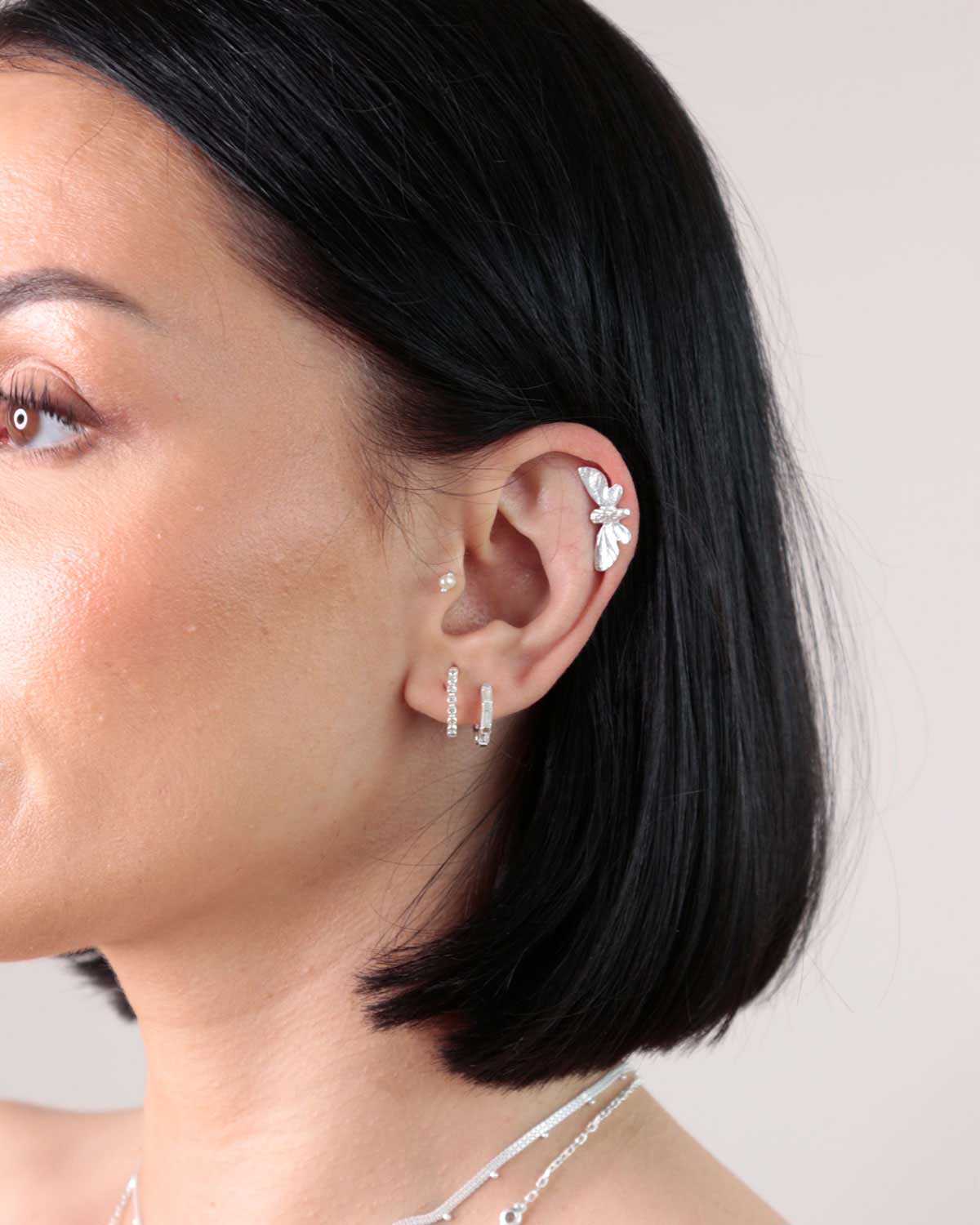 Side view of silver butterfly studs showing secure screw-back and comfortable fit