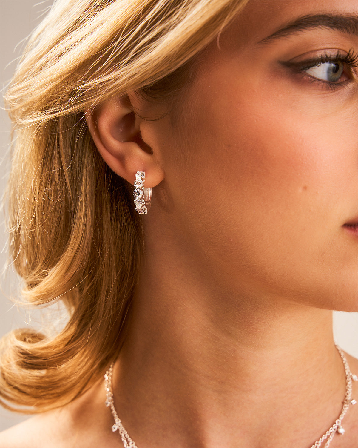 Side view of midsize silver hoop earrings with a lightweight polished design