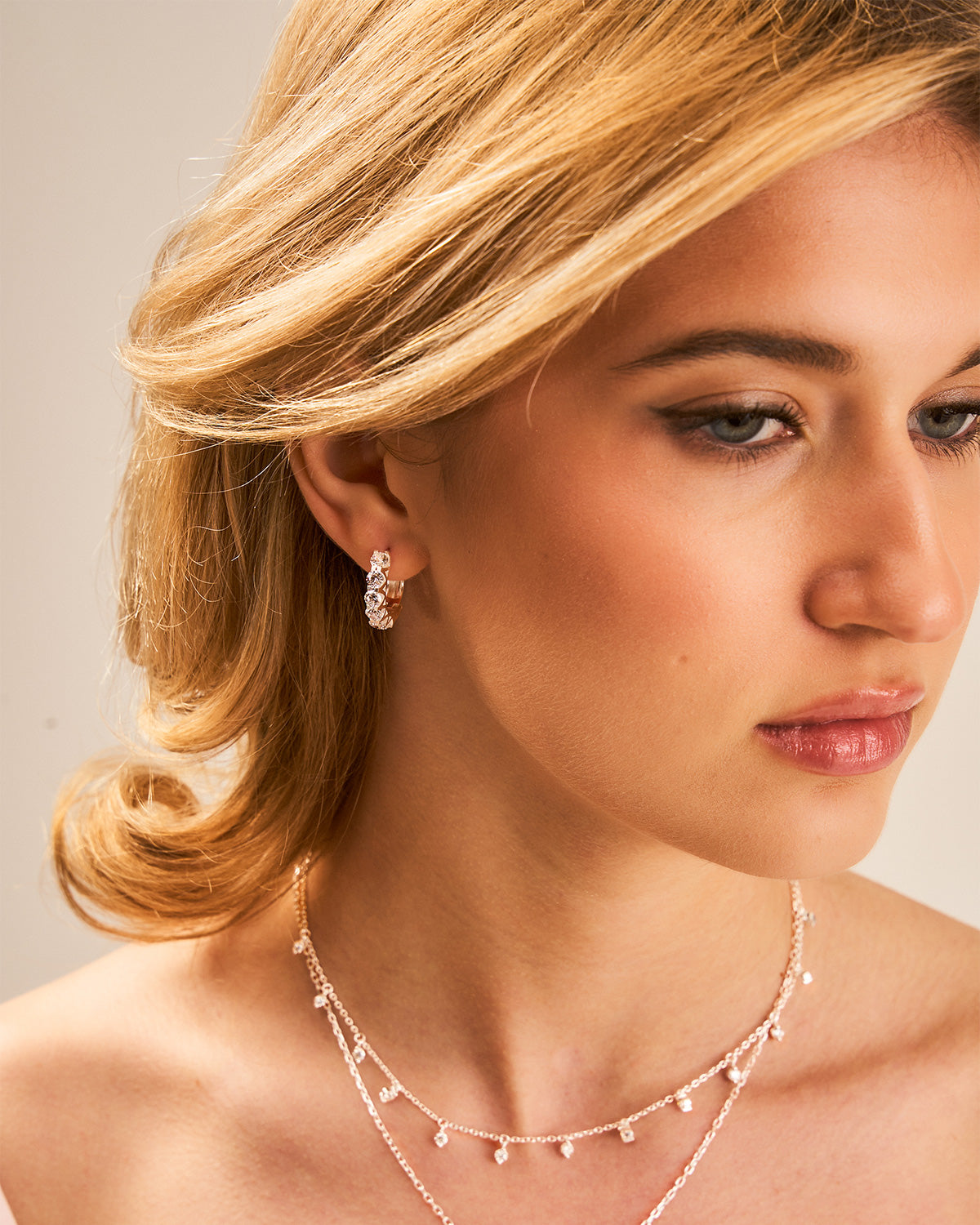 Close-up of a woman wearing a necklace and earrings