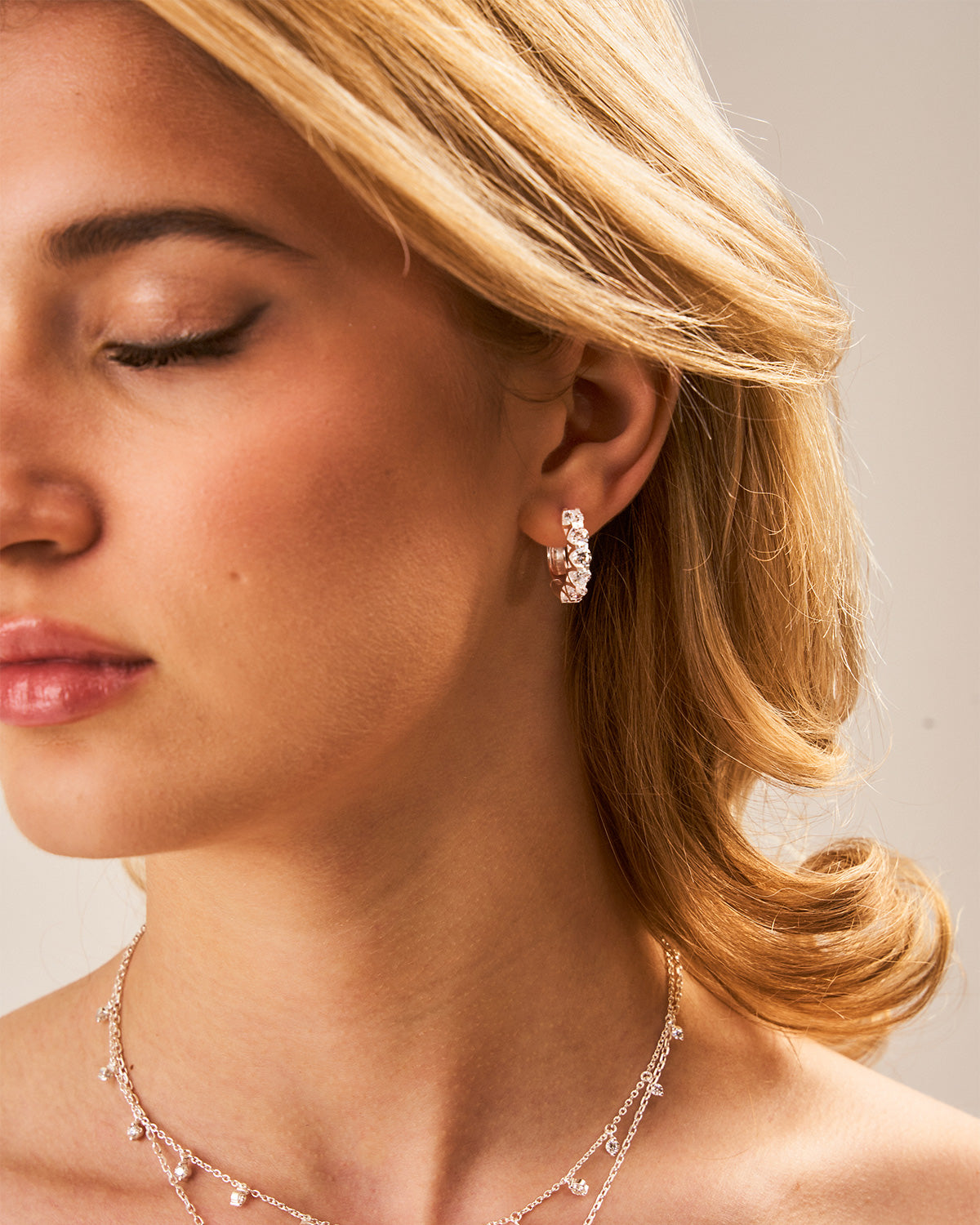 Side view of midsize silver hoop earrings with a lightweight polished design