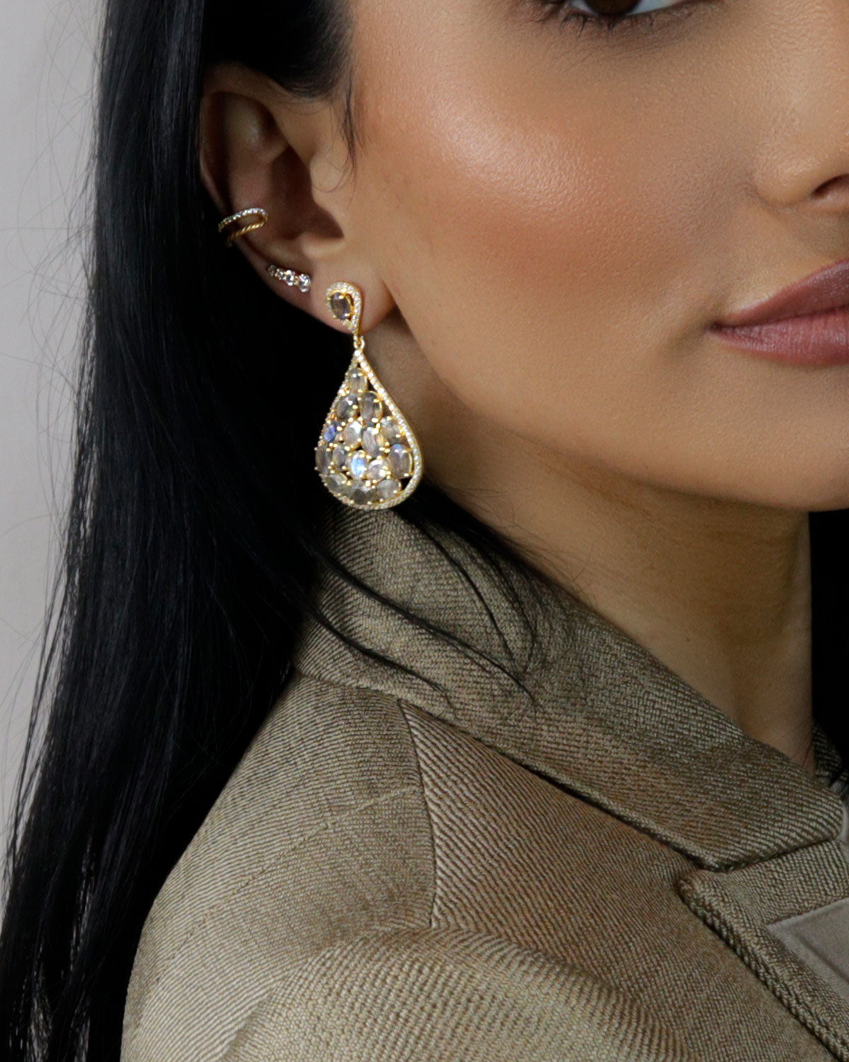 Close-up of labradorite gemstone with crystal accents in silver earrings