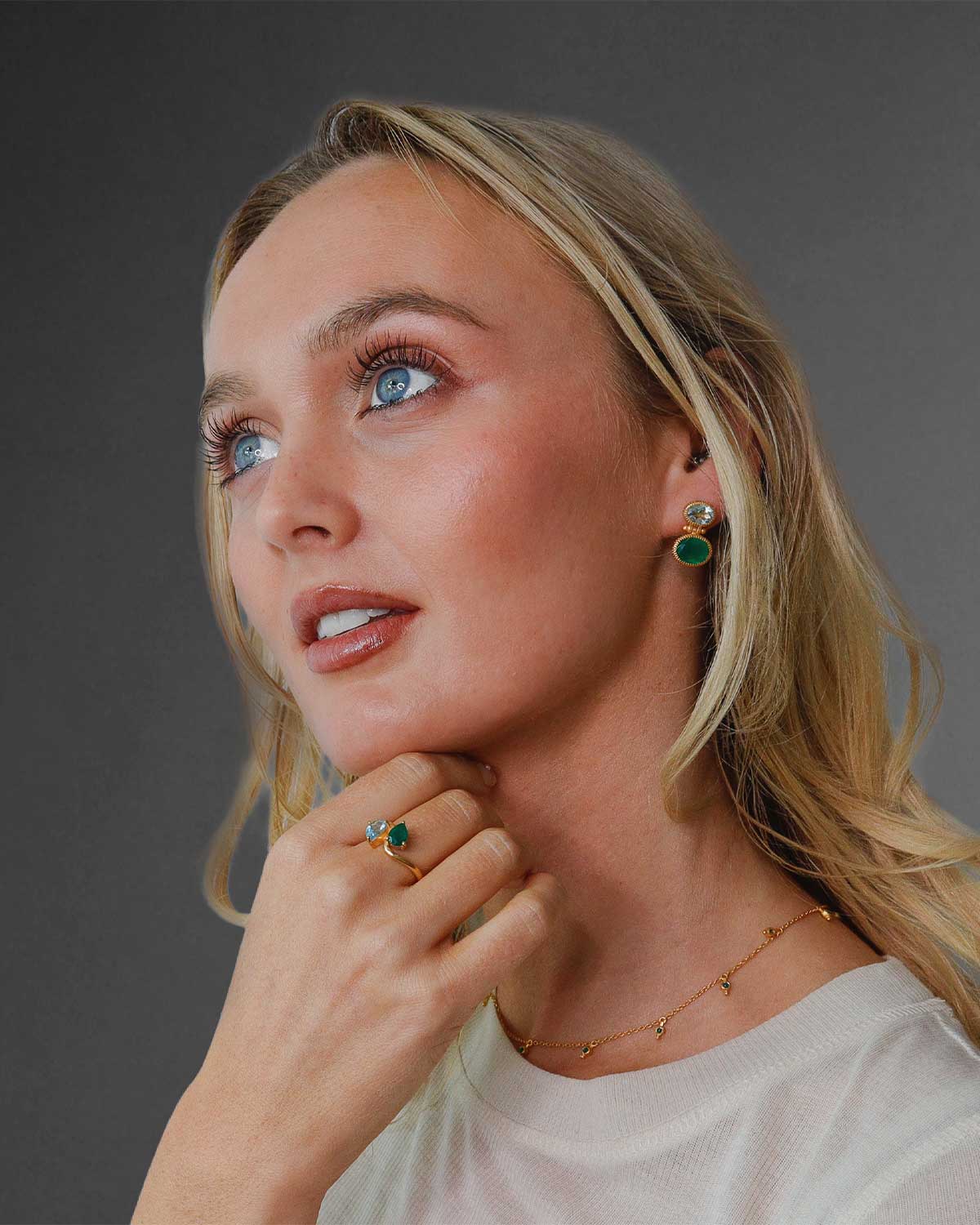 Side view of gold ring highlighting the balanced design of blue topaz and green onyx gemstones