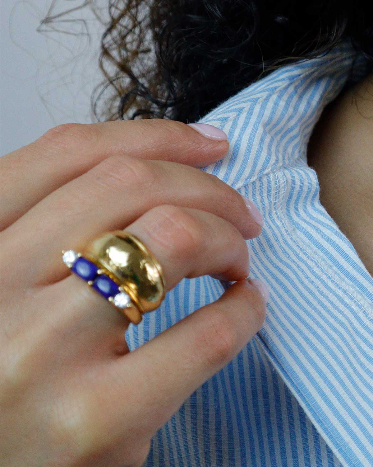 Model wearing a chunky gold ring with a textured finish