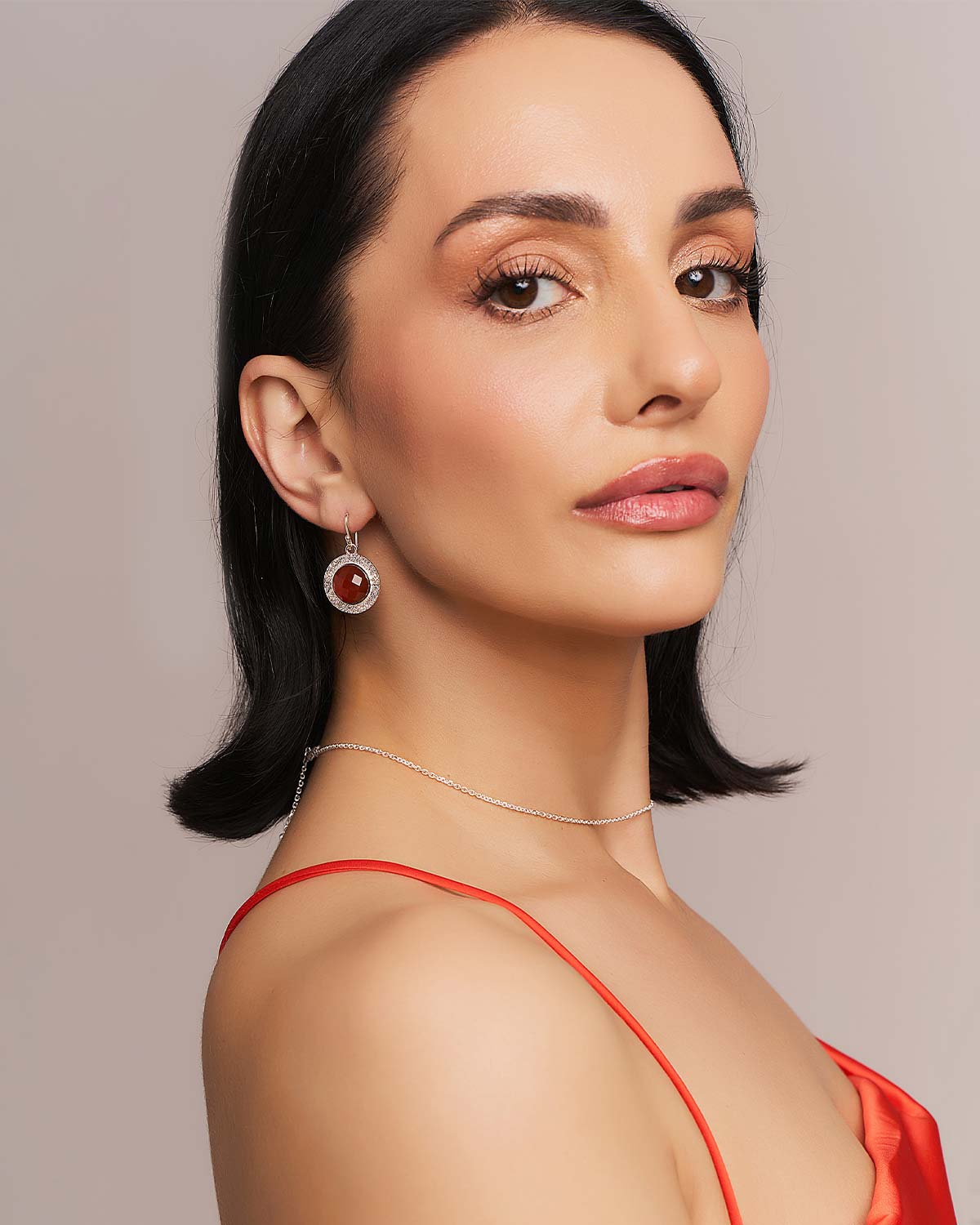 Model wearing sterling silver earrings with circular carnelian gemstones