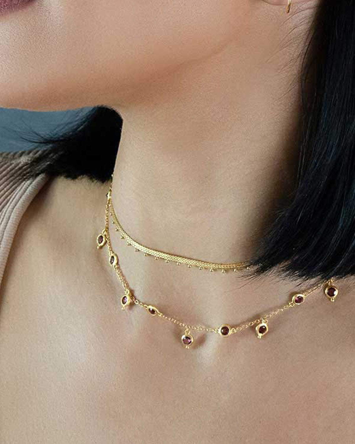 Model wearing sterling silver necklace with rhodolite gemstones