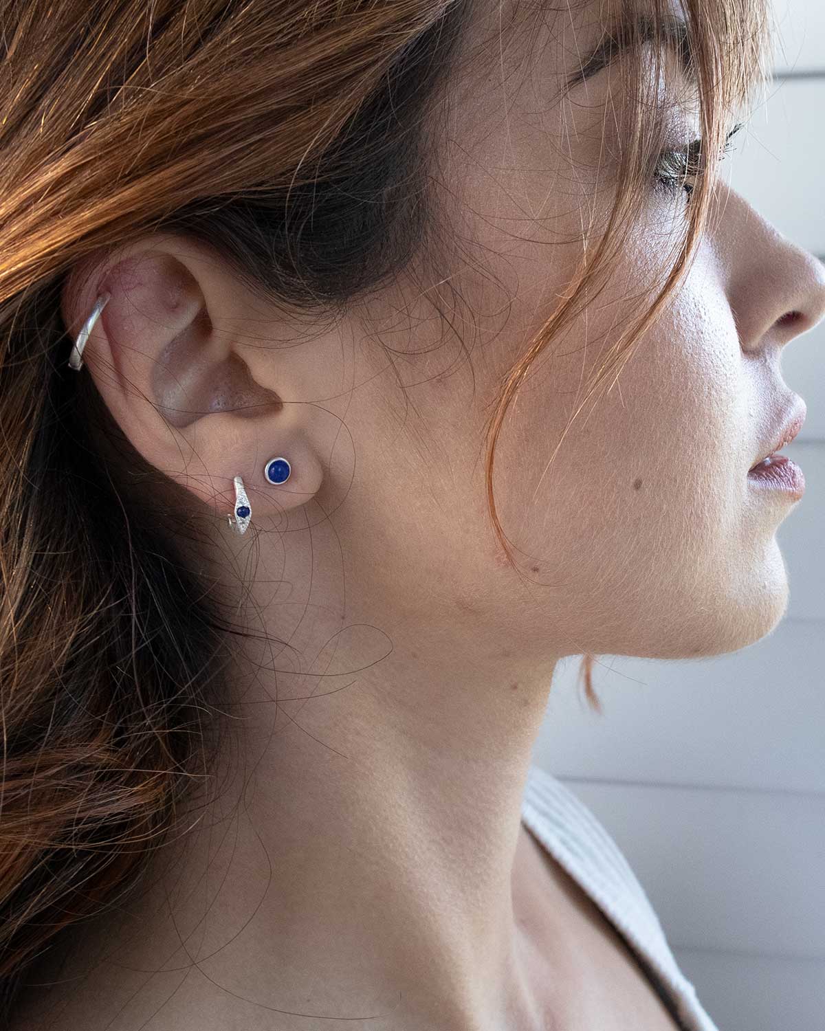 Silver stud earrings featuring a deep blue lapis lazuli gemstone
