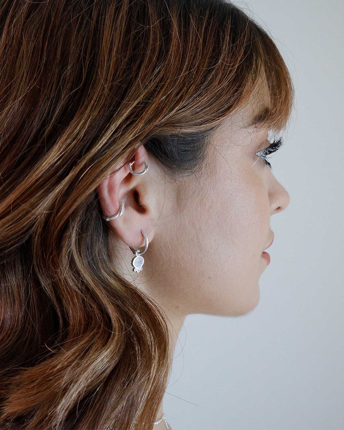 Silver mini hoop earrings with polished finish and moonstone charm