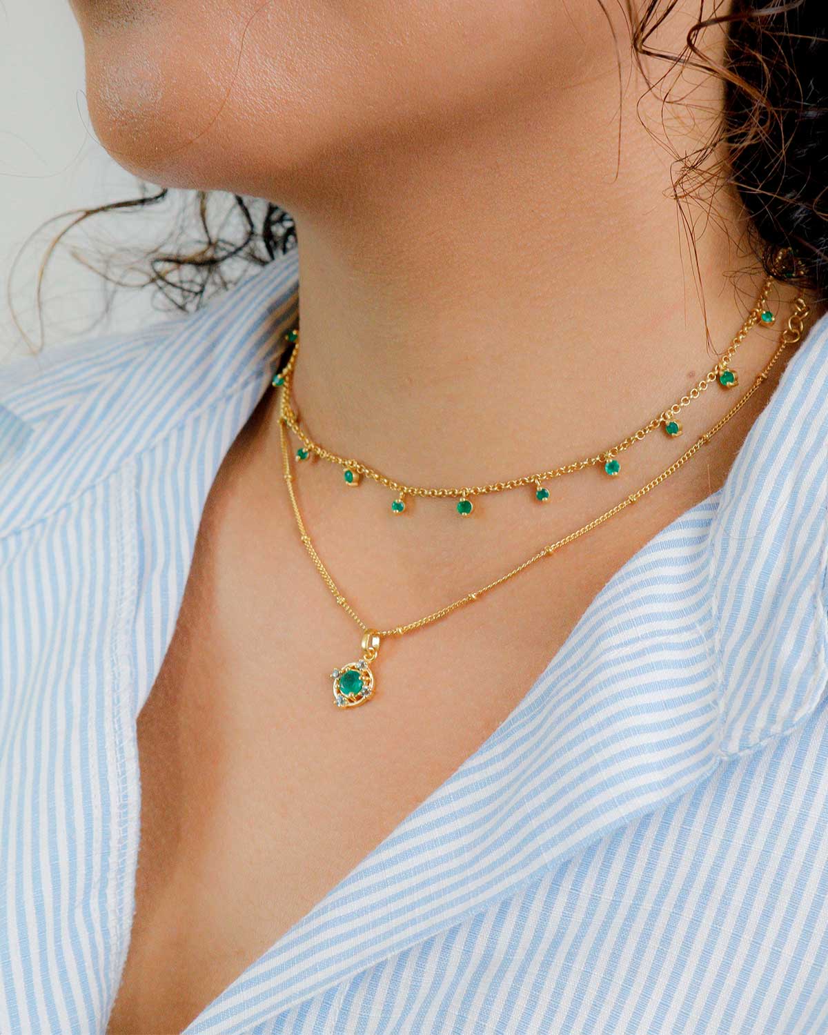Front view of gold necklace with green onyx and blue topaz stones
