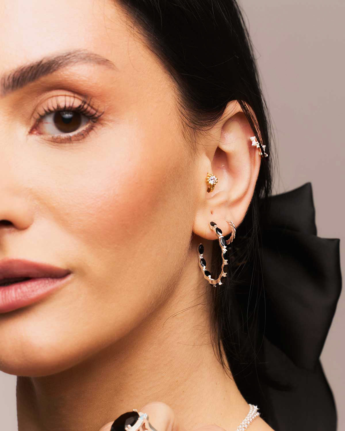 Silver hoop earrings with hand-set black spinel gemstones and a polished finish