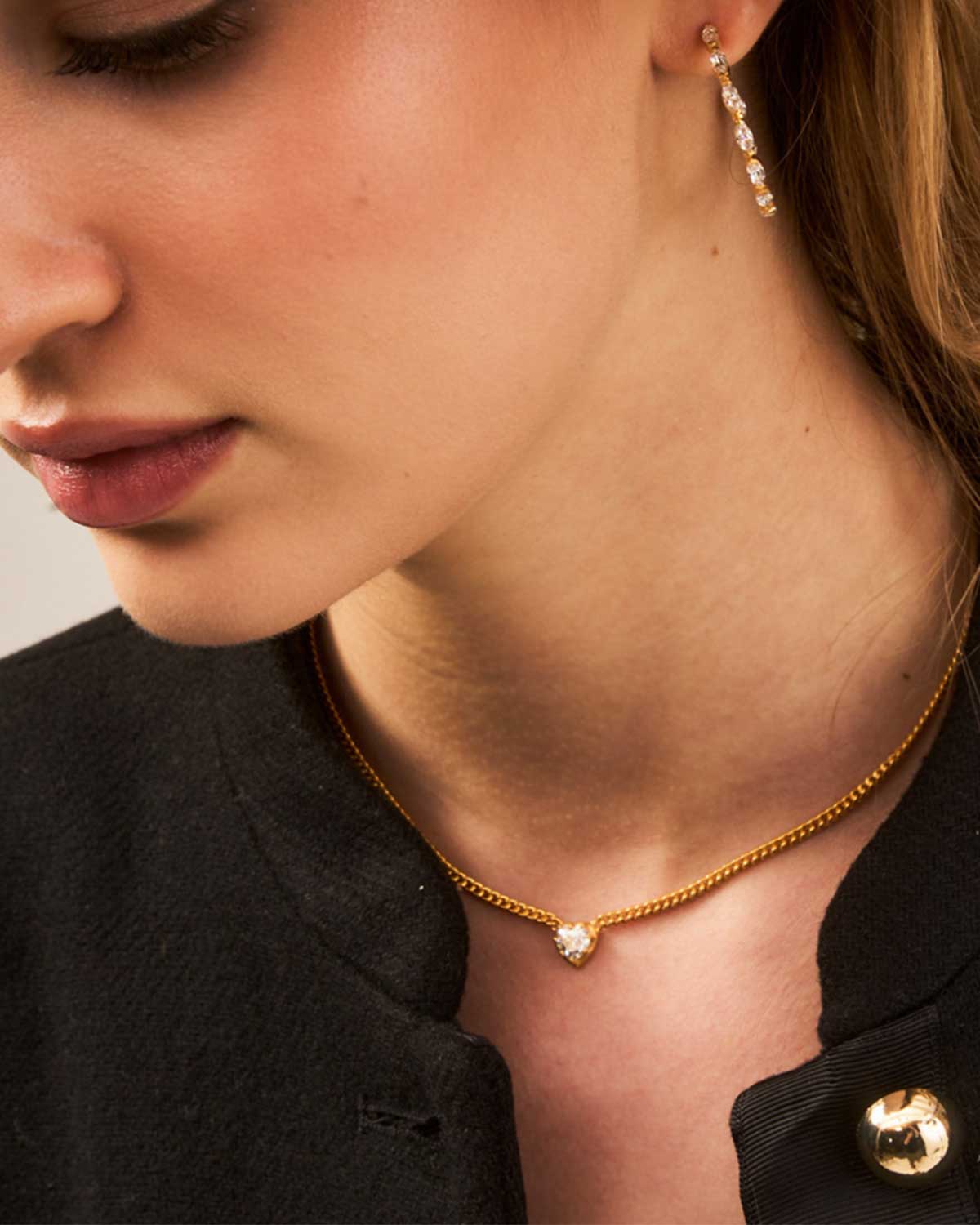 Model wearing gold necklace with diamond heart pendant and adjustable chain