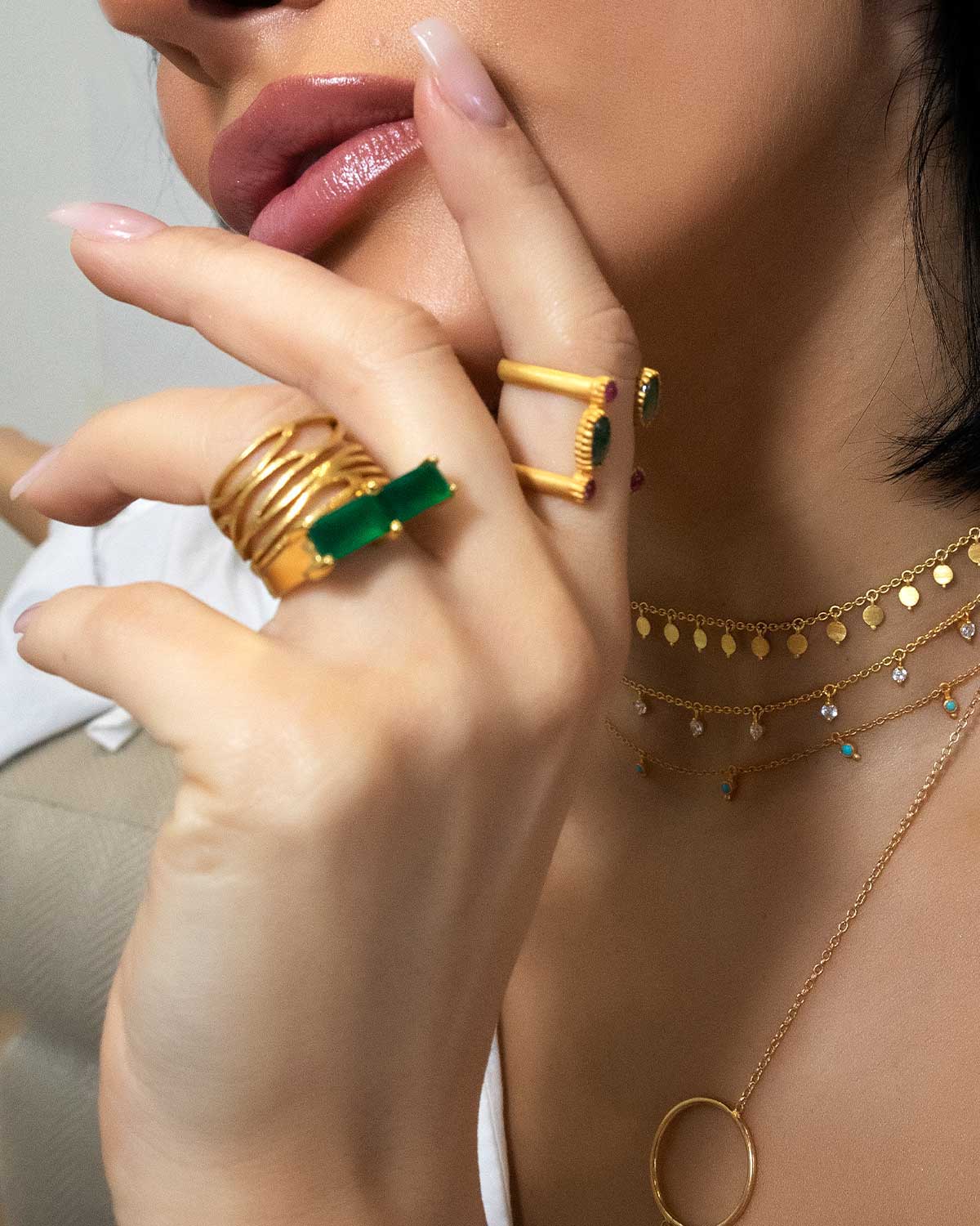 Model wearing bold gold ring with a green onyx gemstone