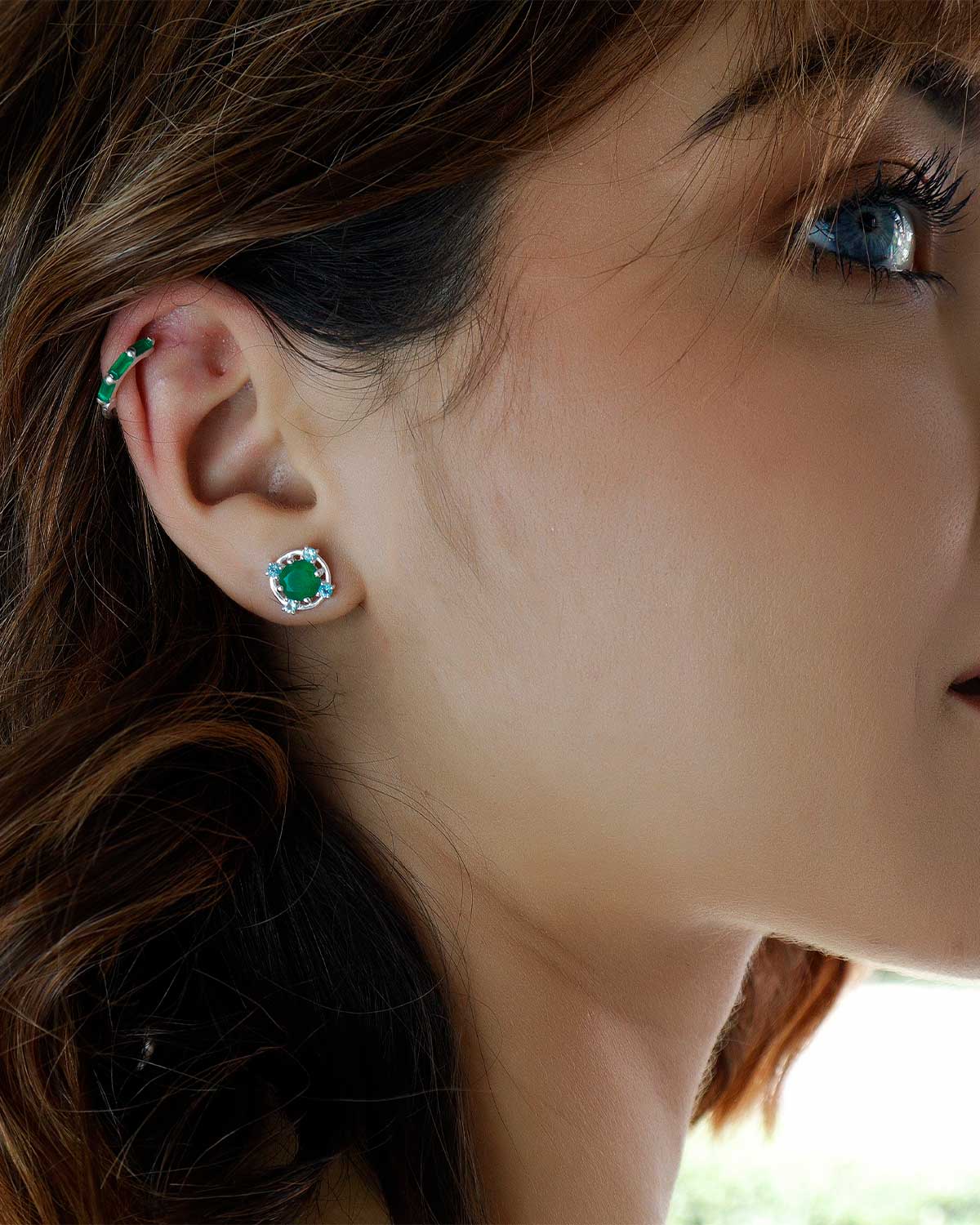 Detailed view of green onyx and blue topaz gemstones in silver studs