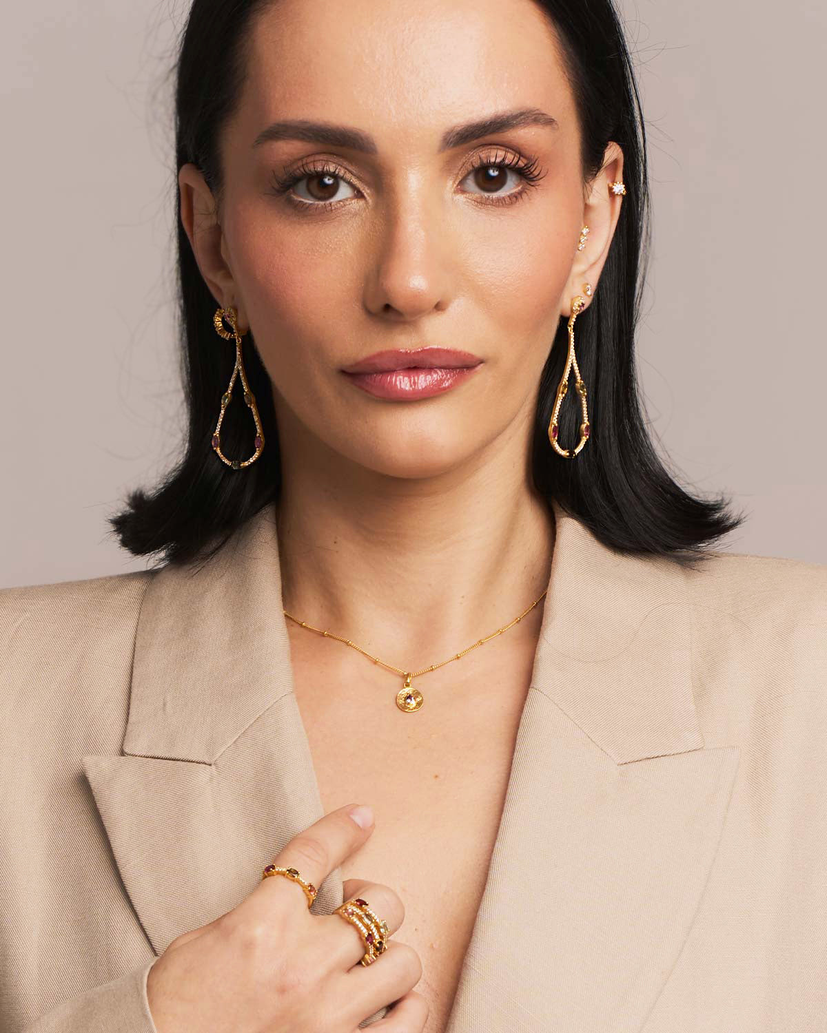 Model wearing gold drop earrings with mixed-colour tourmaline gemstones
