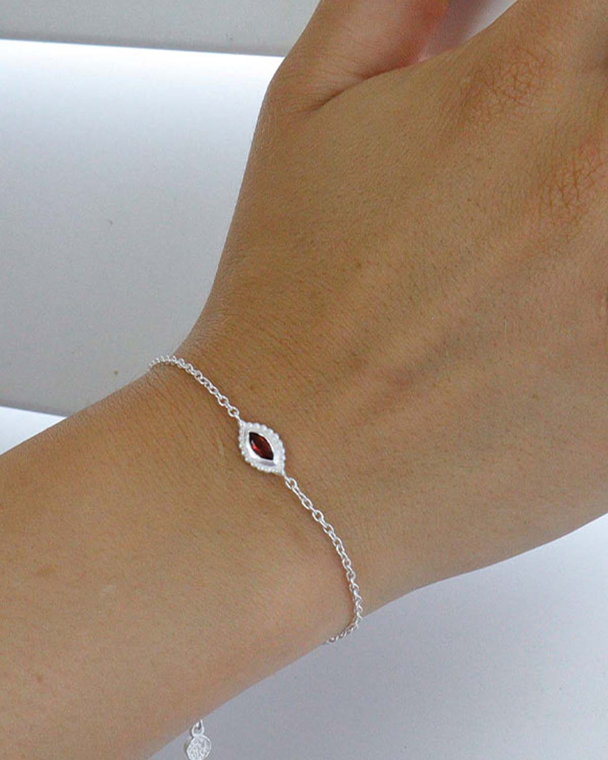 Close-up of silver bracelet with hand-cut amethyst, garnet and aqua gemstones