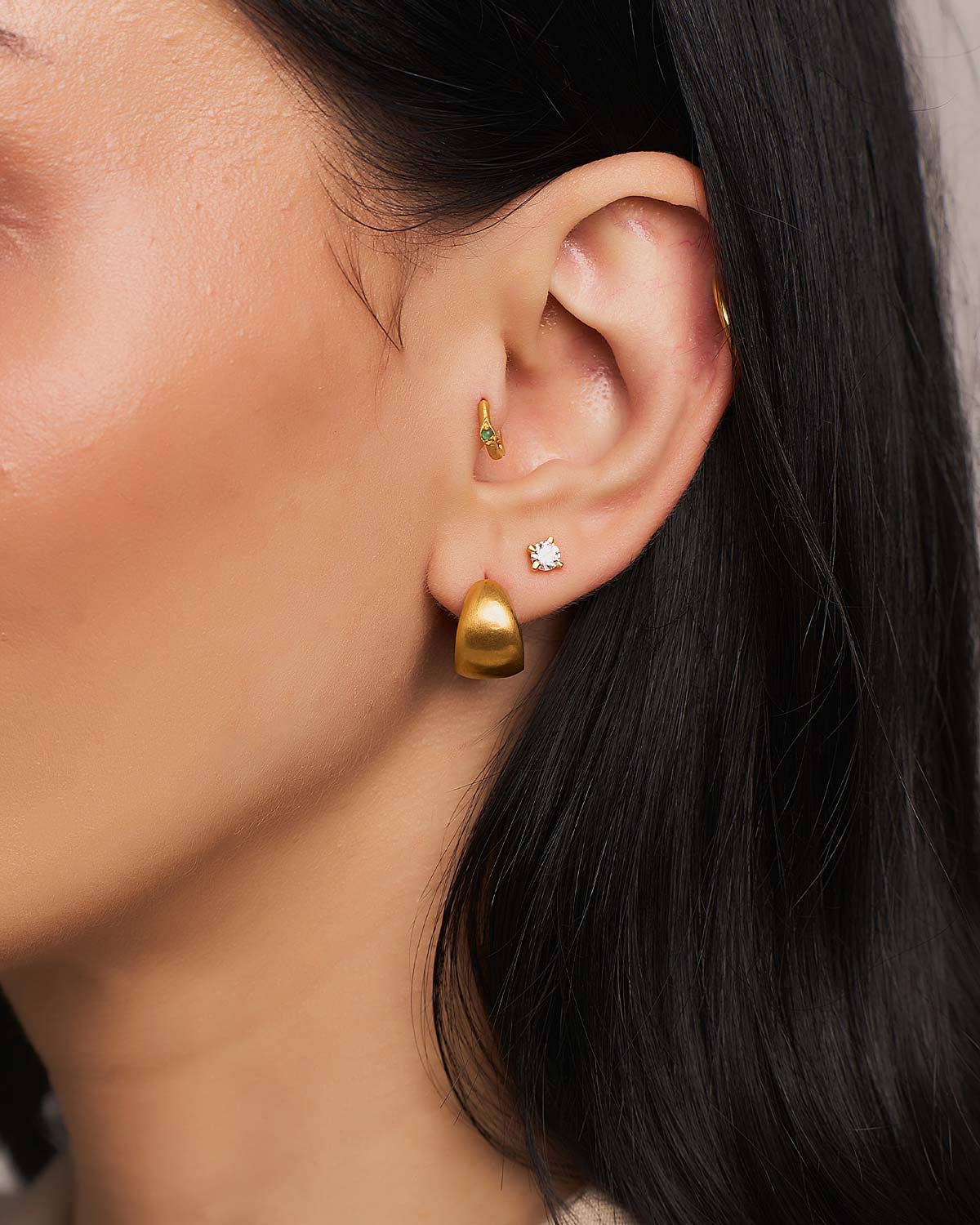Close-up of gold stud earrings with white moissanite diamonds and secure setting