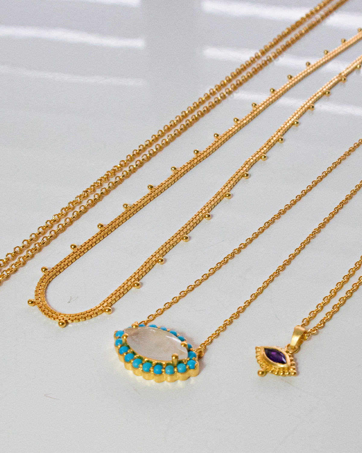 Unique gold eye necklace with turquoise and rainbow moonstone gemstones