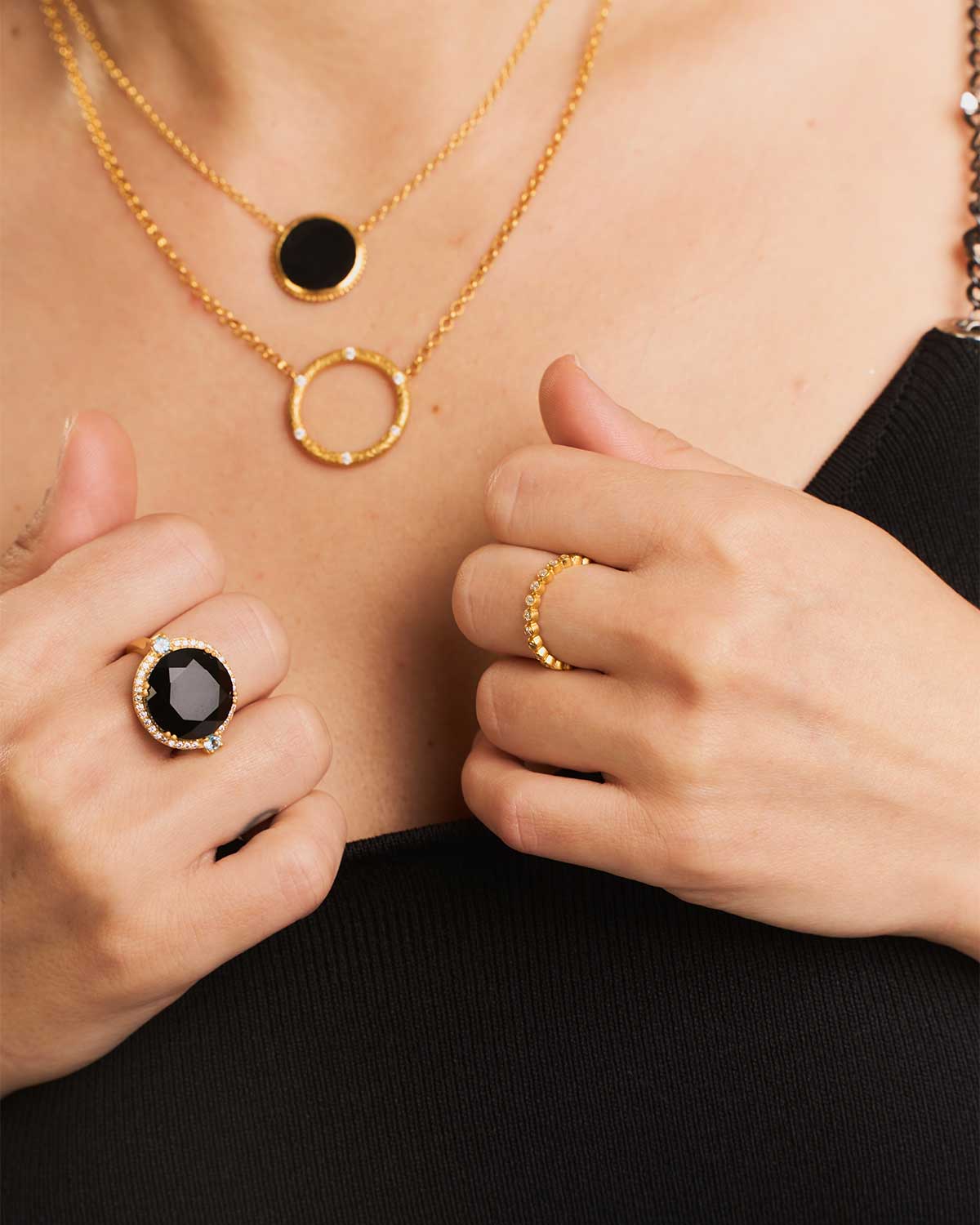 Model wearing gold ring with black spinel gemstone and sparkling diamonds
