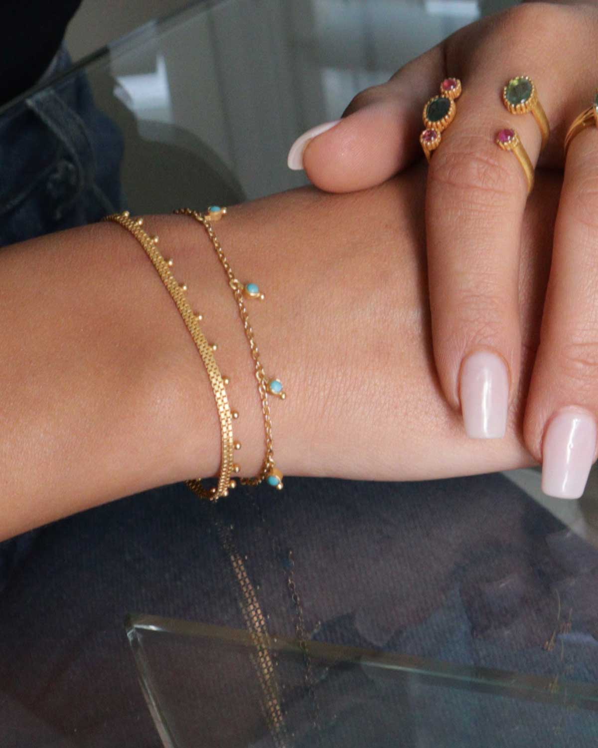 Adjustable gold bracelet worn on wrist with delicate handmade ball details