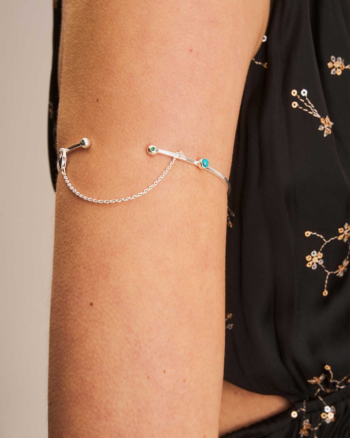 Silver arm cuff with turquoise stones on a model's arm