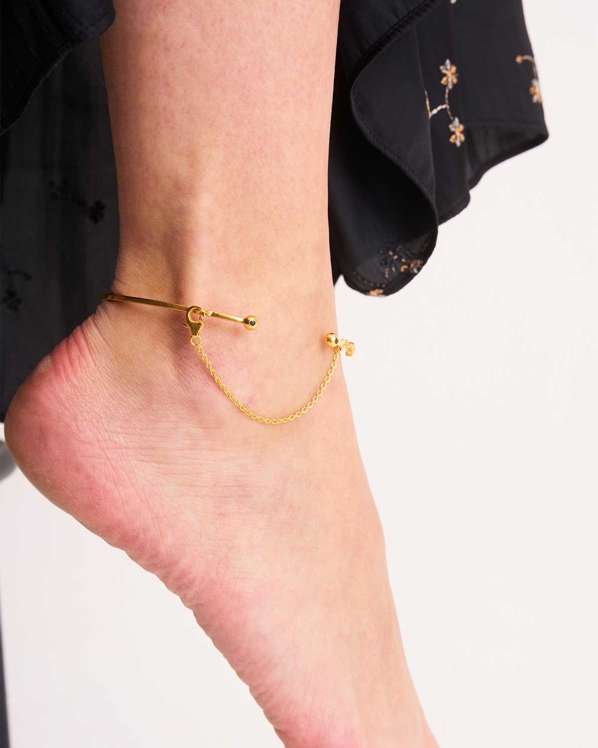 Model wearing silver arm cuff with black spinel, green onyx, and turquoise