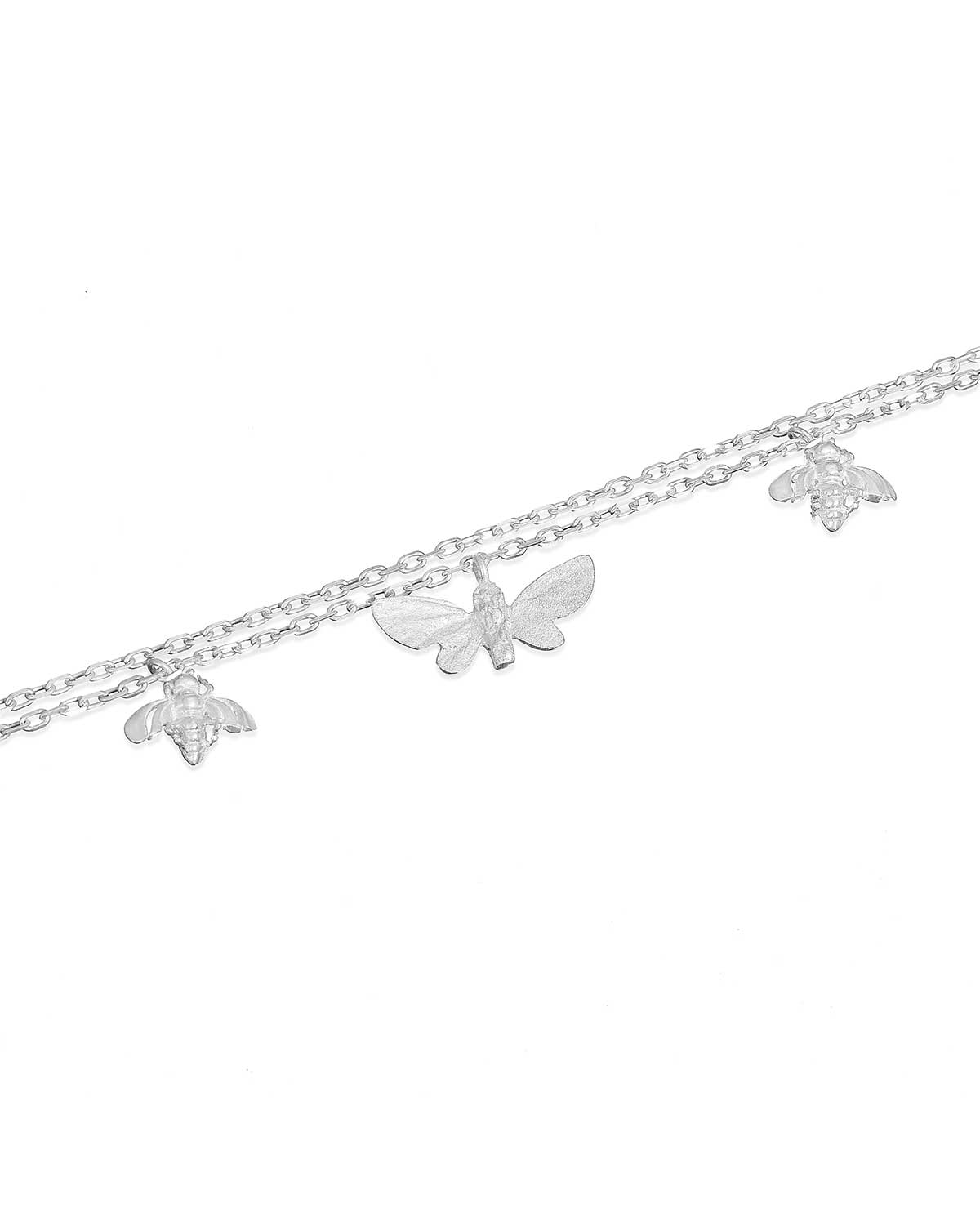 Detailed view of butterfly and bee charms on sterling silver bracelet