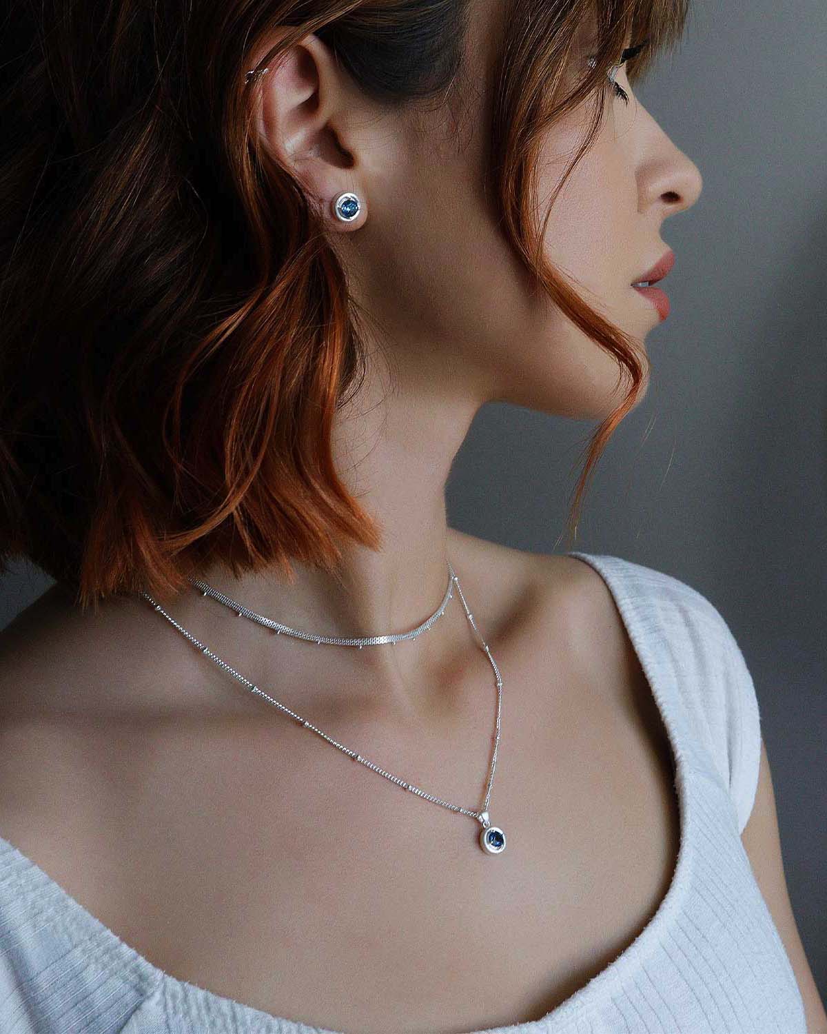 Close-up of sterling silver necklace with deep blue topaz gemstone