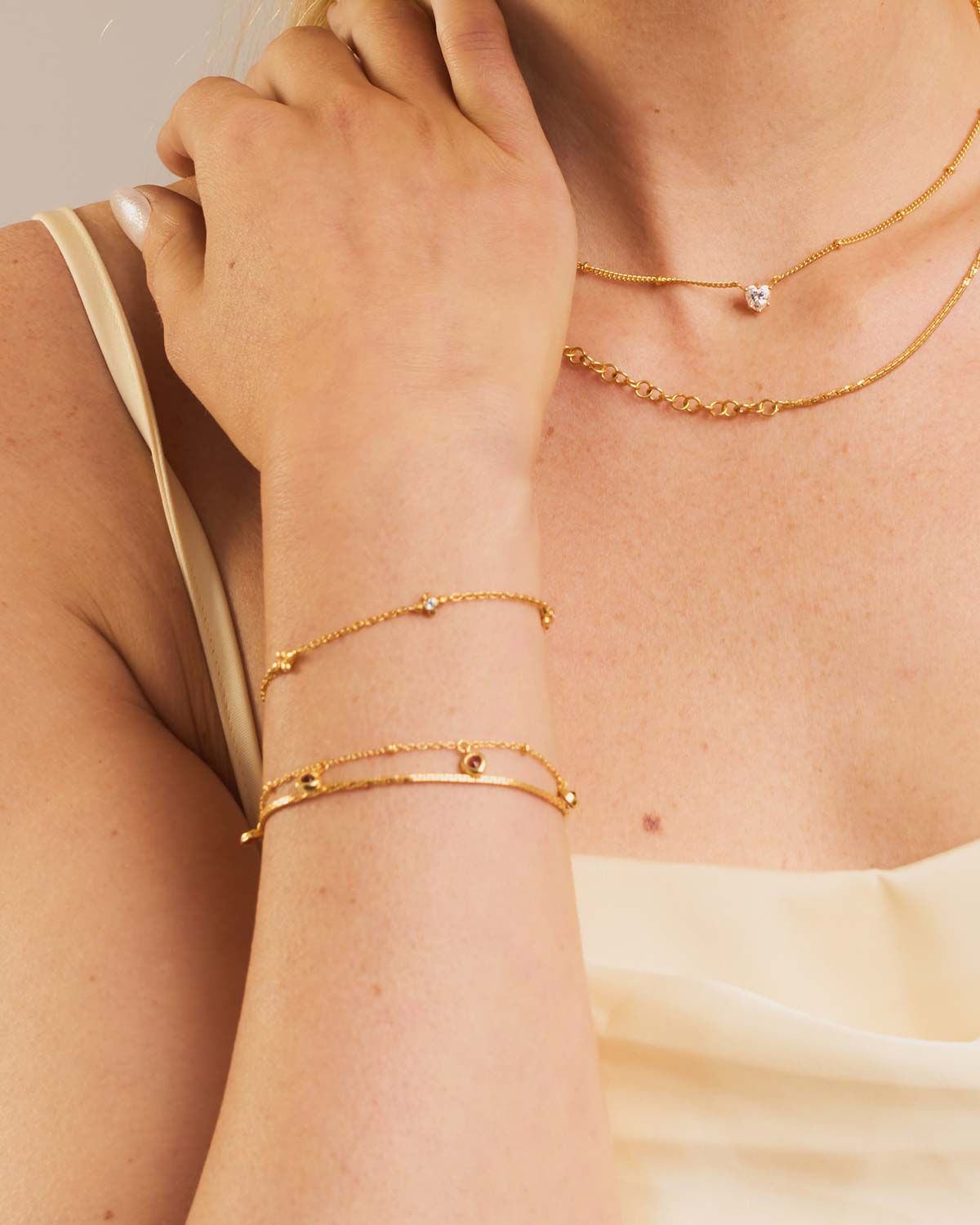Gold bracelet with blue topaz gemstones and diamonds styled in a layered bracelet stack
