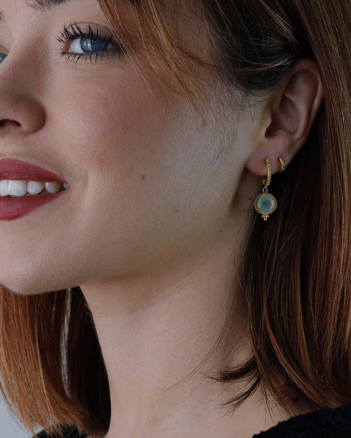 Close-up of gold mini hoops with aqua chalcedony gemstone drops