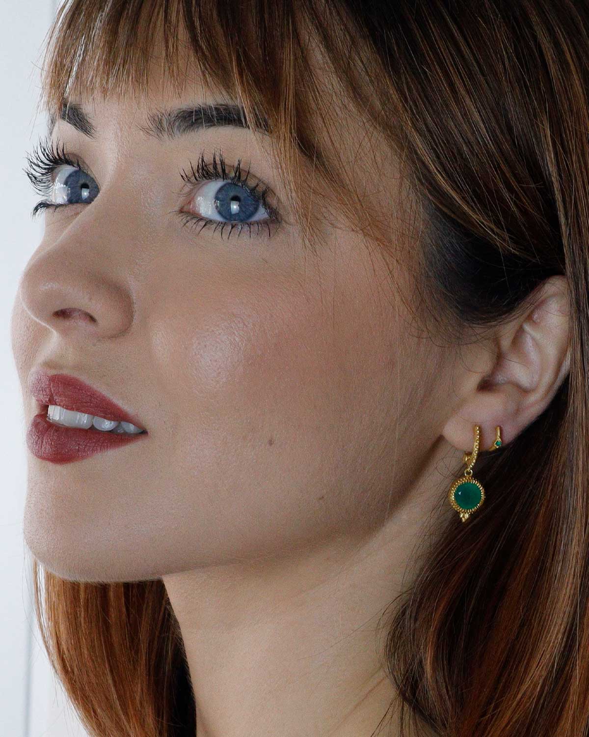 Side angle of gold mini hoop earrings with green onyx gemstones