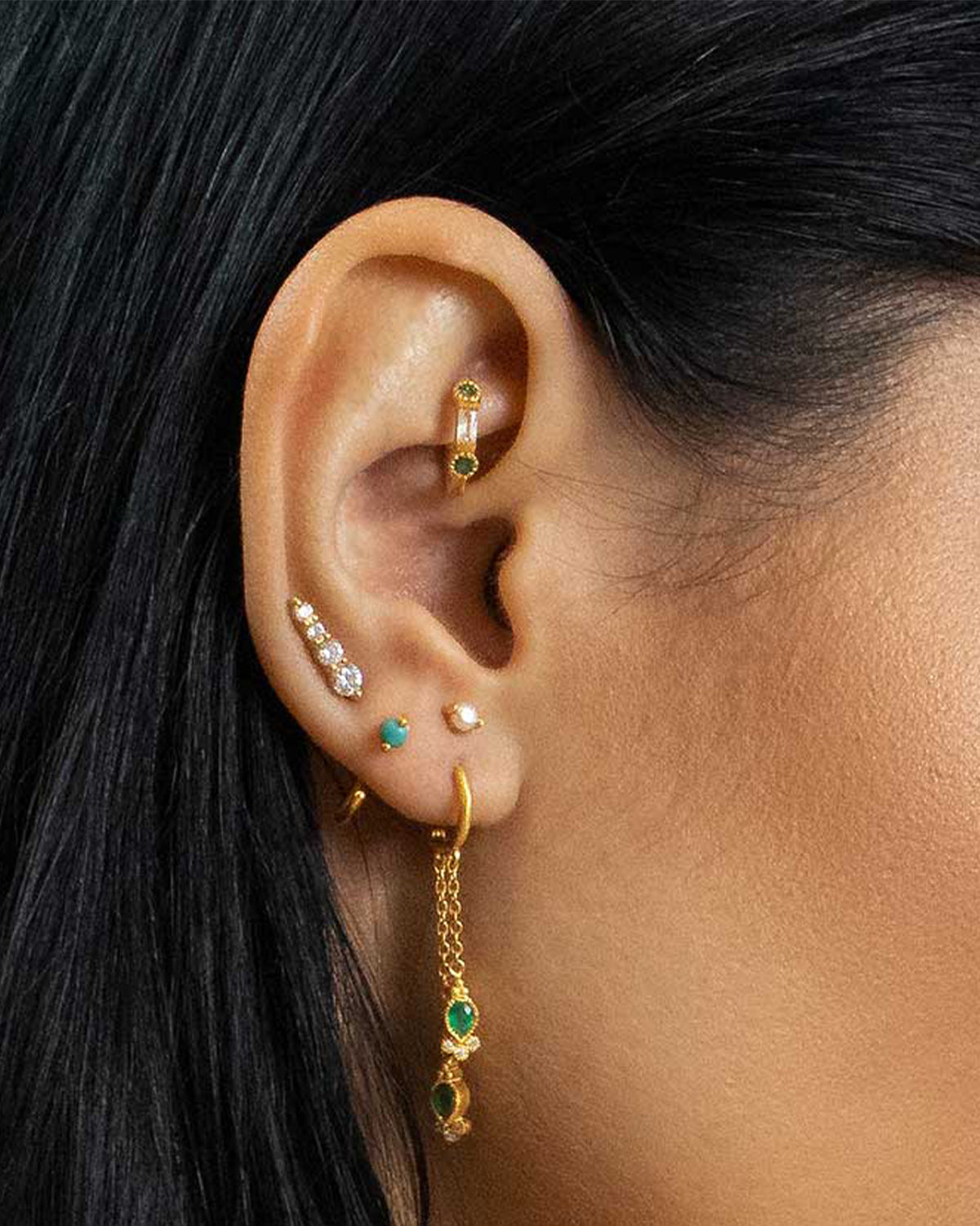 Lightweight gold mini hoop earrings with emerald gemstones for daily wear