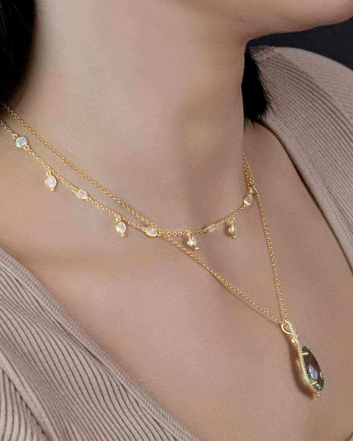 Close-up of silver necklace featuring rainbow moonstone gemstones
