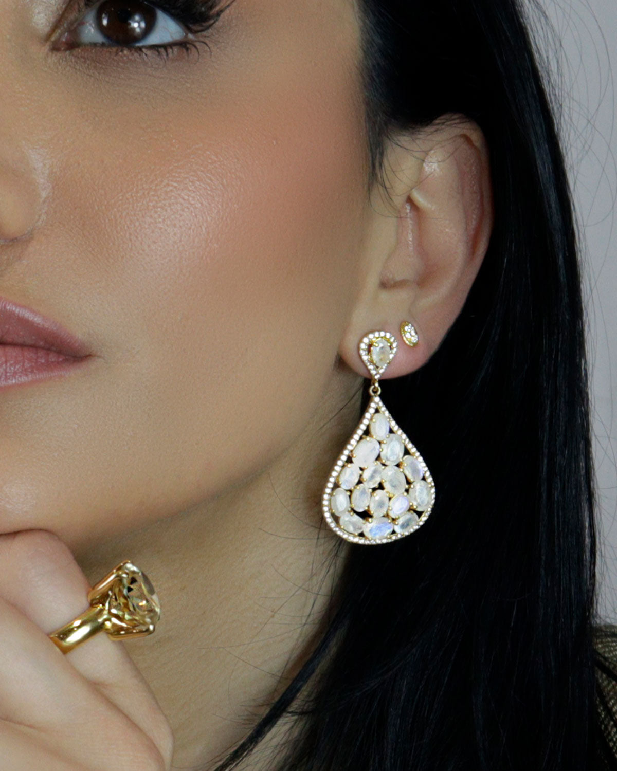 Front view of statement gold earrings with moonstone and crystals