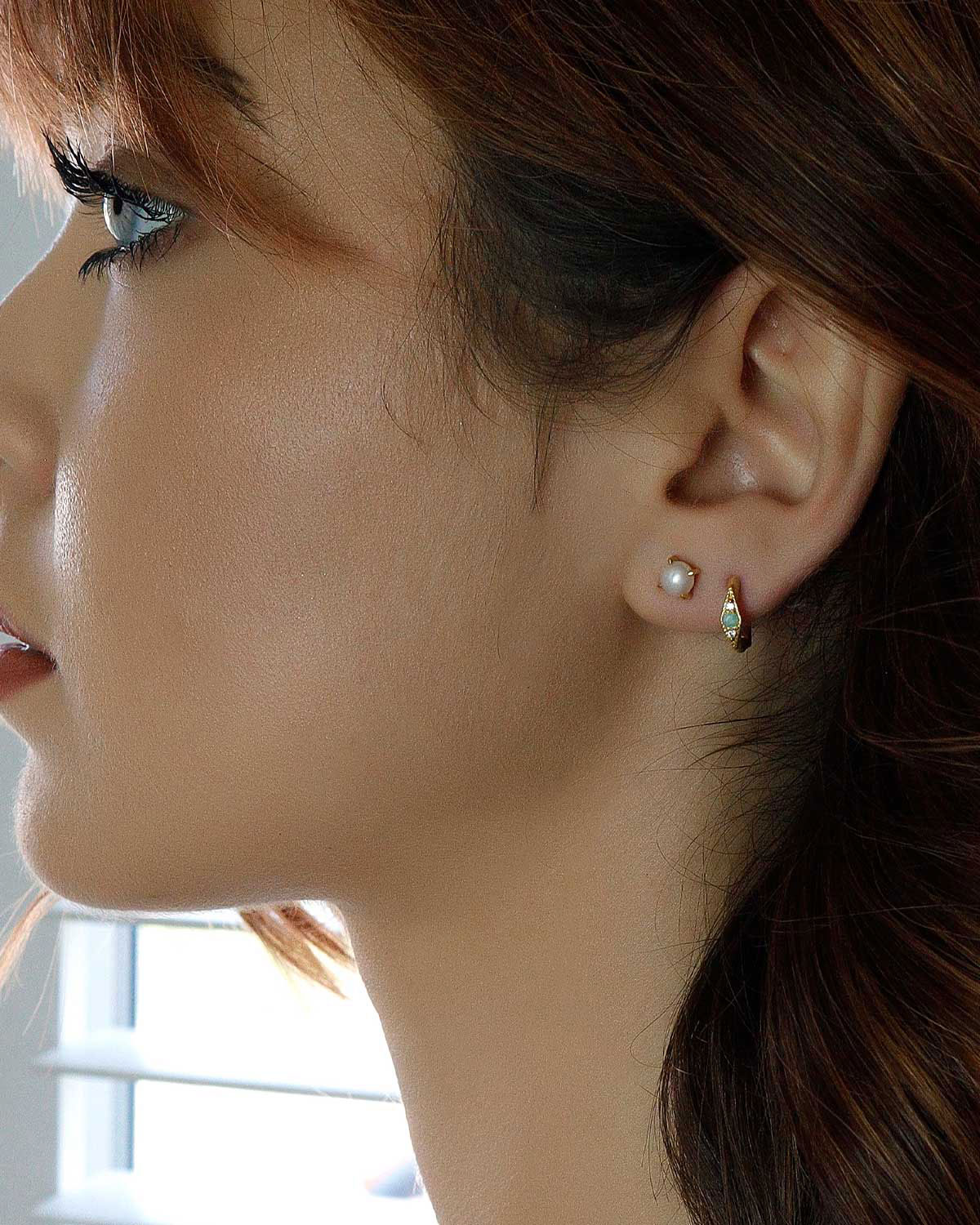 Model wearing sterling silver stud earrings with natural pearls