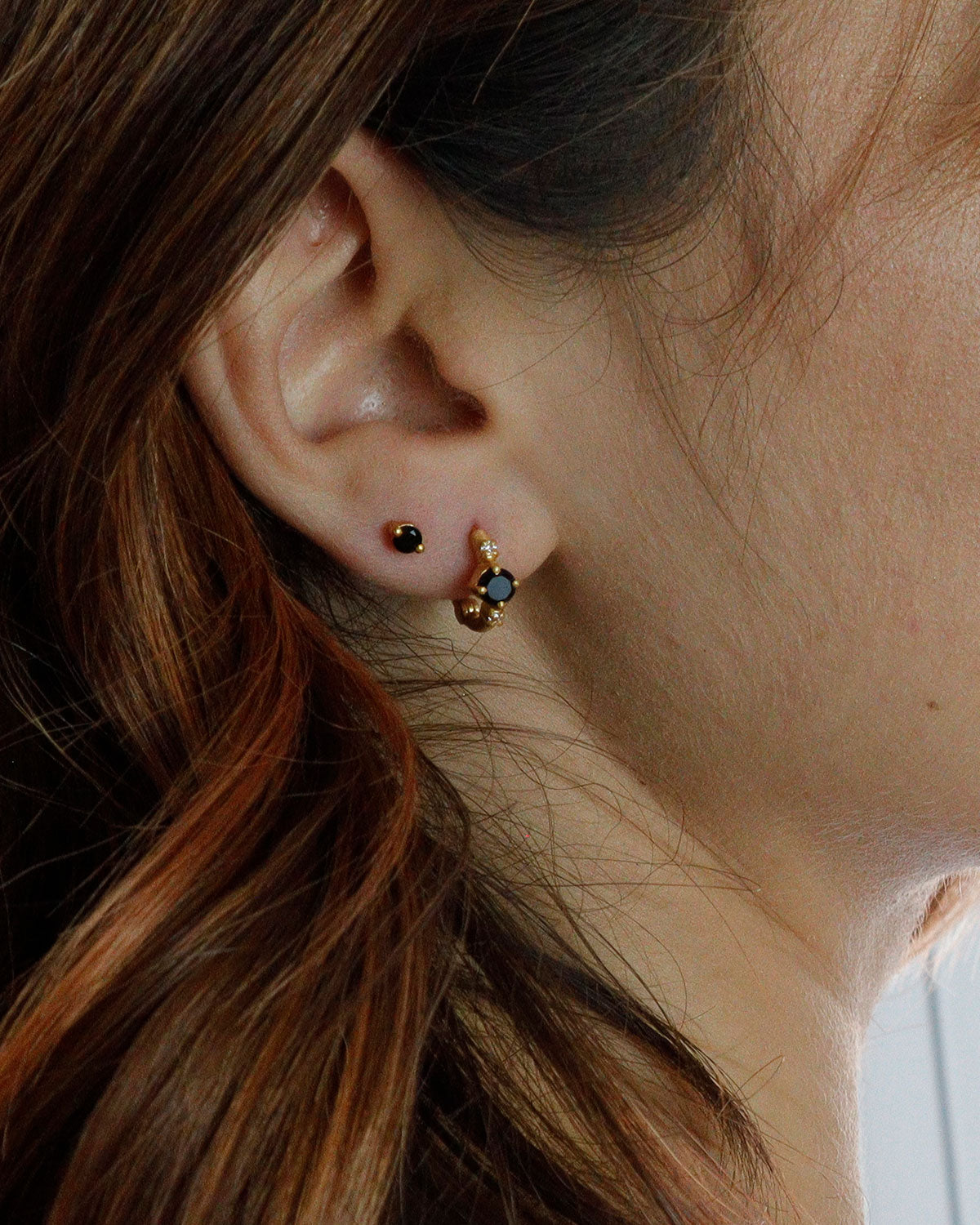 Side angle of gold mini hoops with black spinel gemstones and pearls
