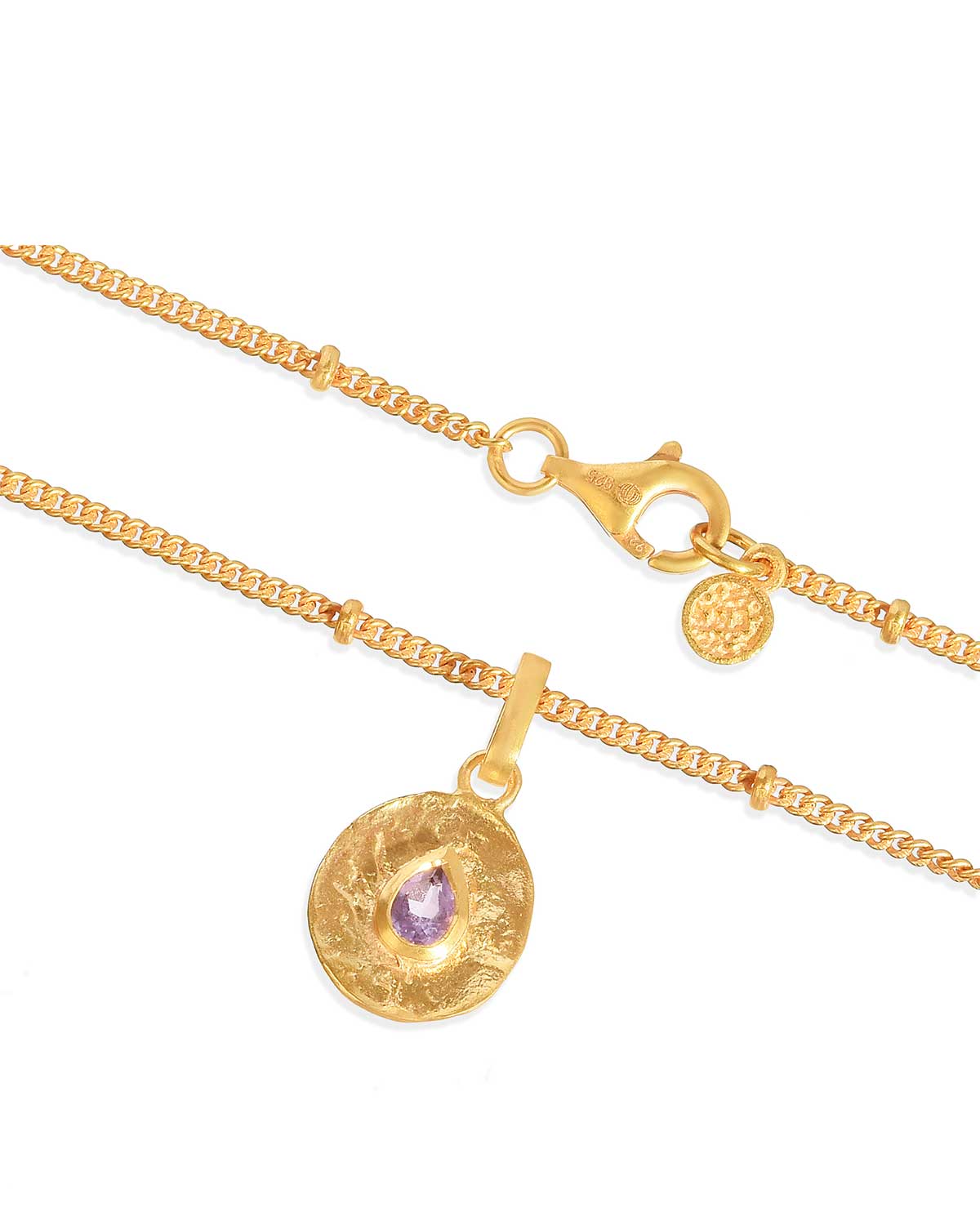 Gold necklace with a round pendant featuring a purple gemstone