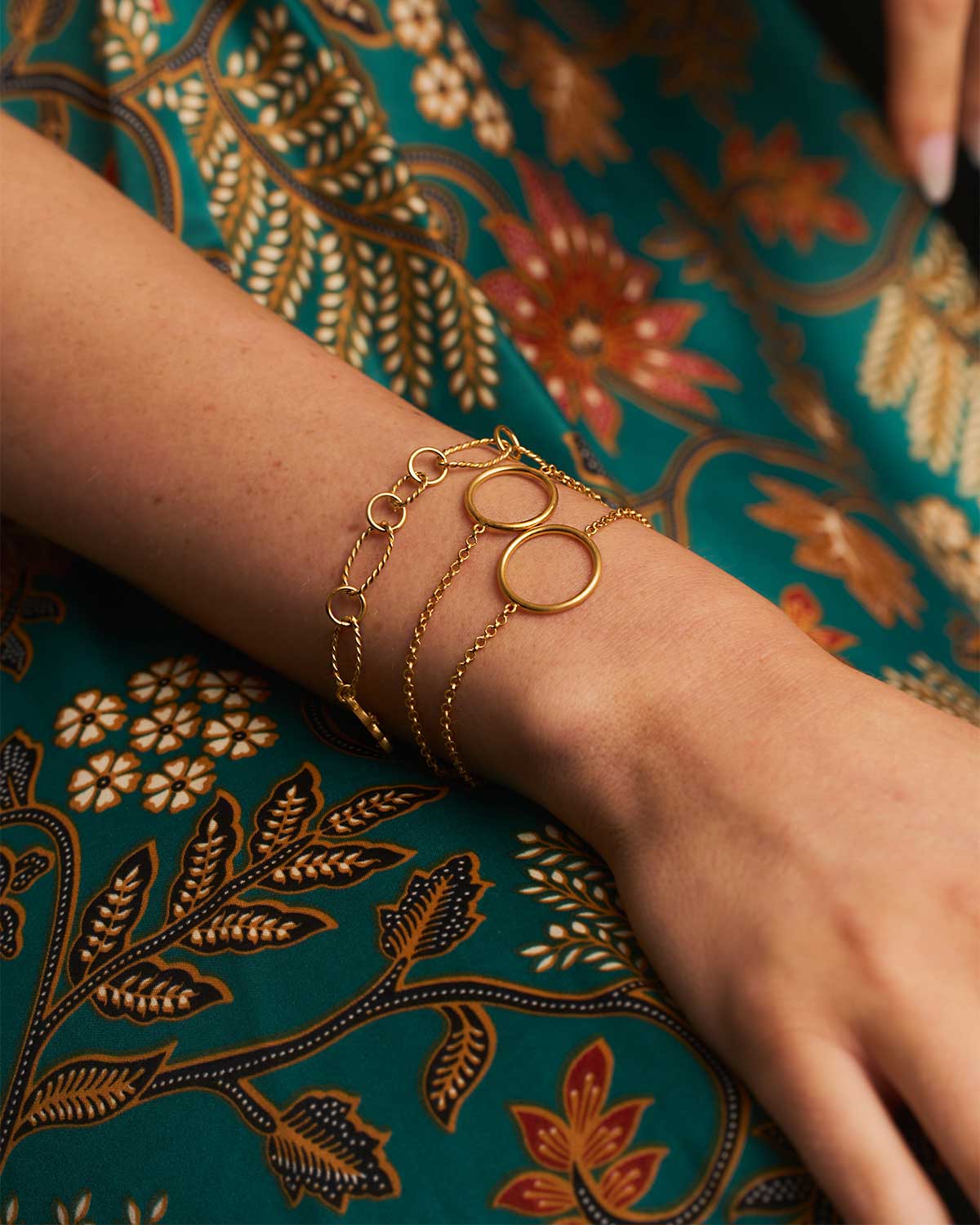 Model wearing a gold adjustable bracelet with layered circle details