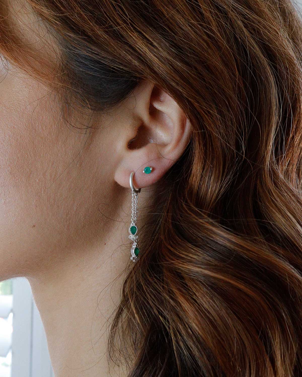 Close-up of mini hoops with hand-cut green onyx gemstones and crystal detail