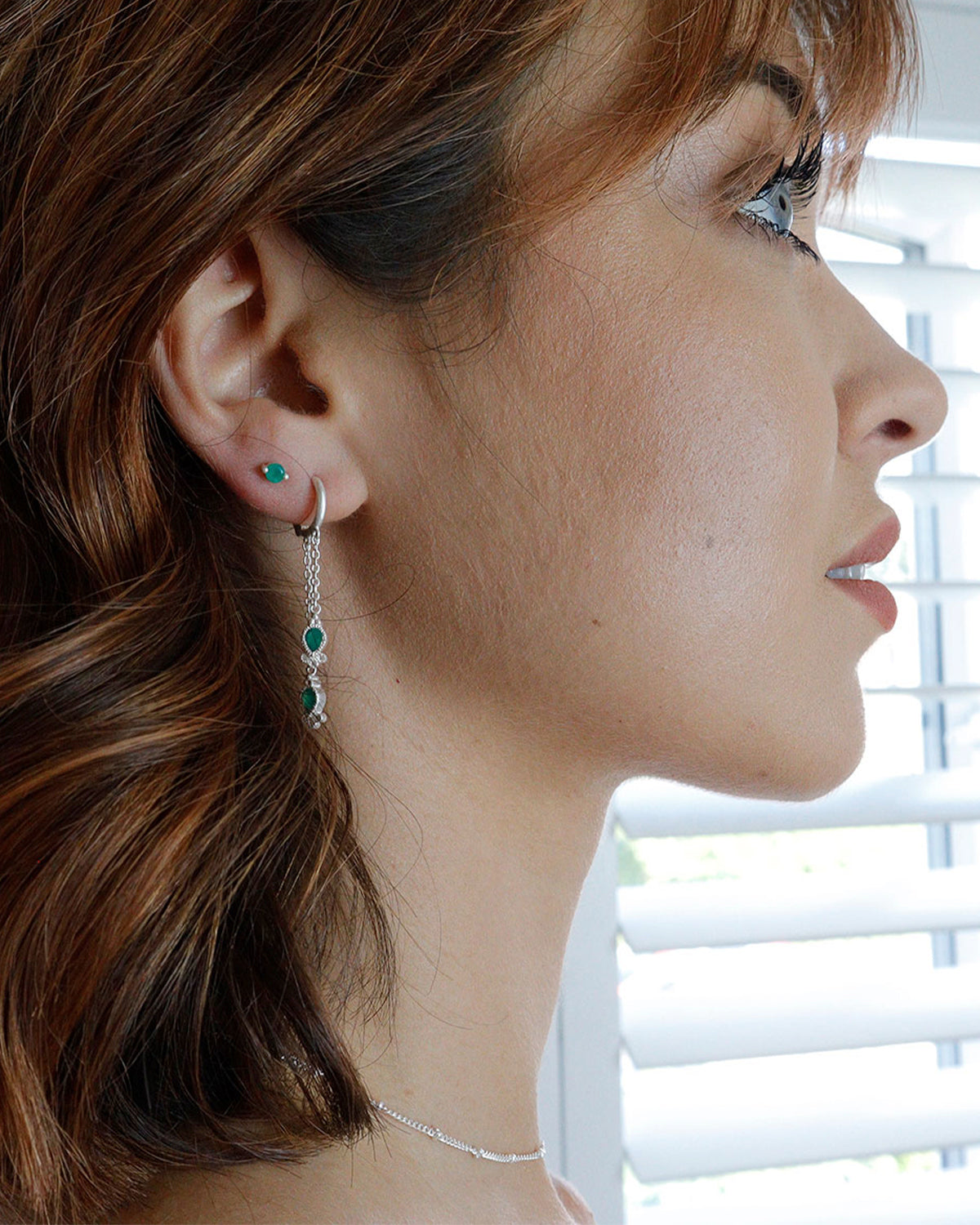 Side angle of mini hoops highlighting green onyx gemstones and crystal accents