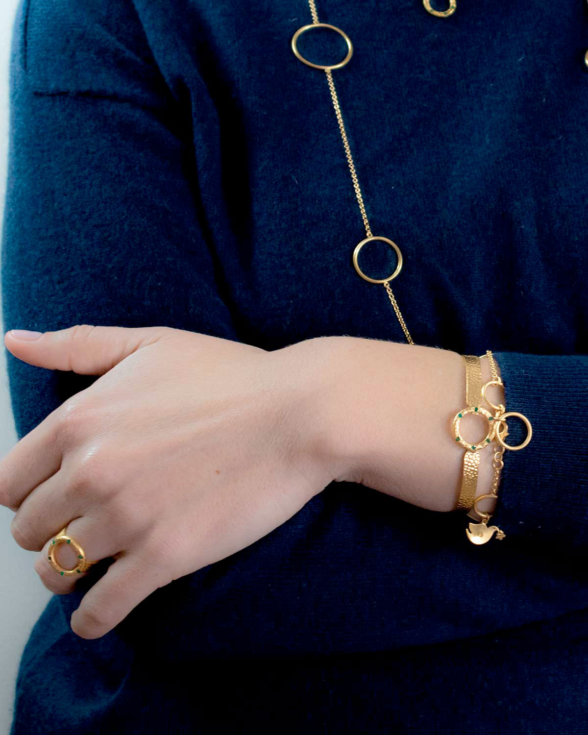 Close-up detail of a hammered gold flexible bangle with gemstone accents