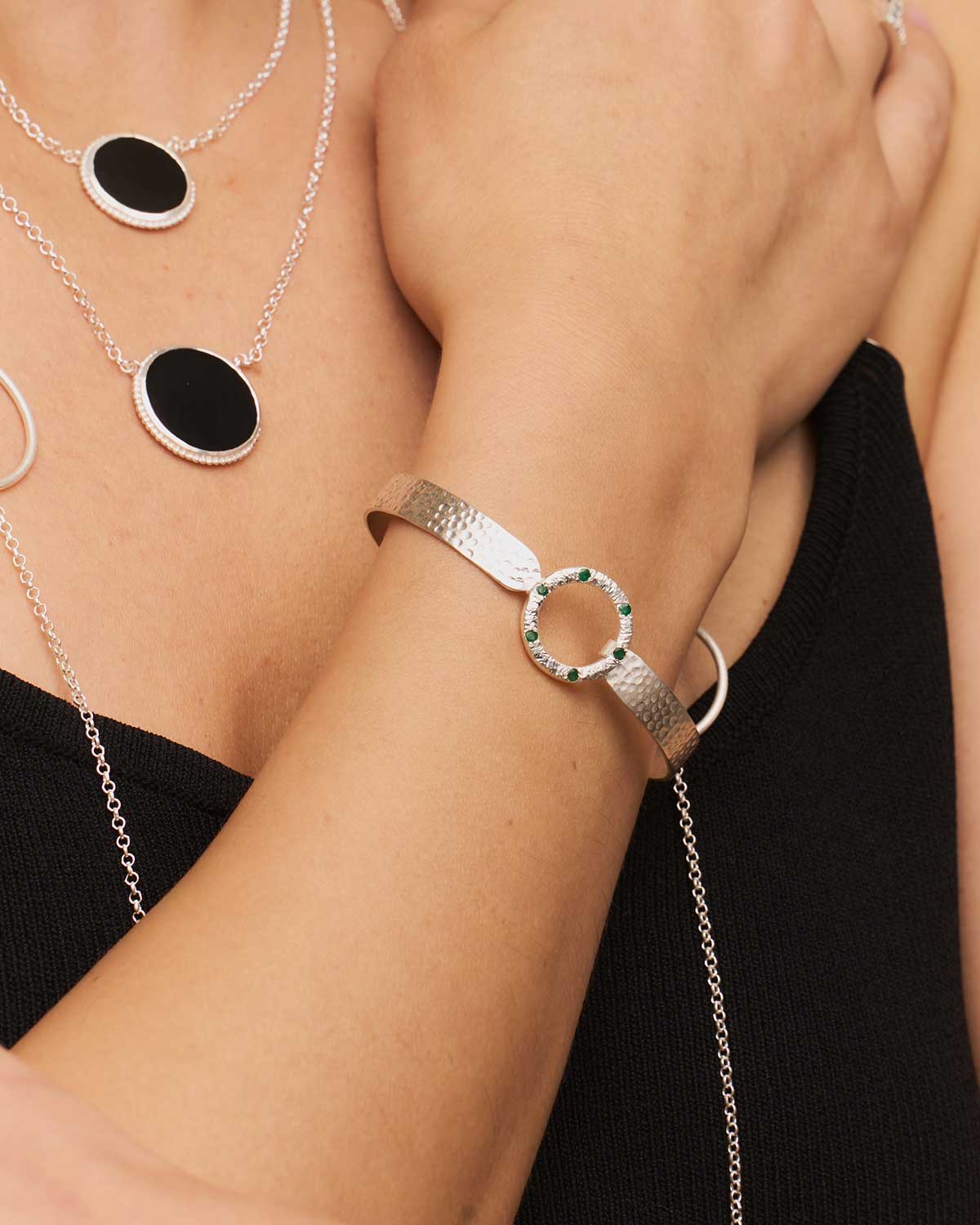 Close-up of hammered sterling silver flexible bangle with gemstone accents