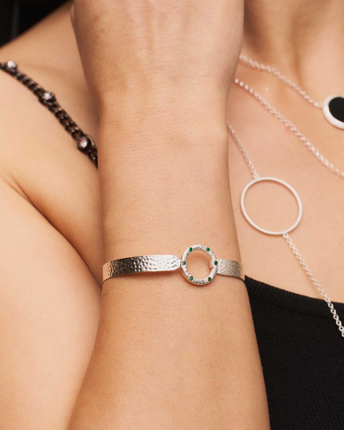 Sterling silver flexible bangle with natural emerald gemstones and a hammered finish