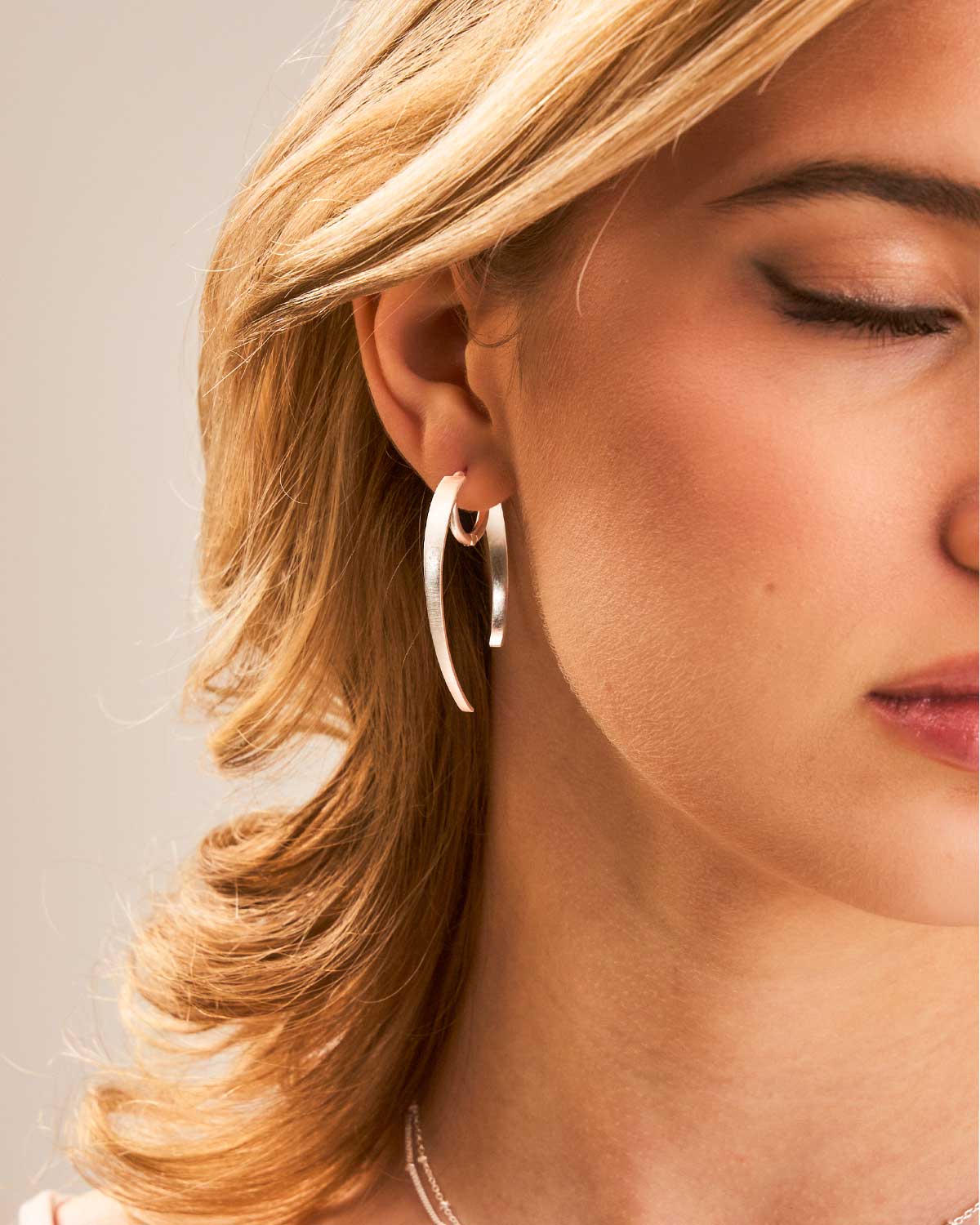 Close-up of a woman wearing silver hoop earrings. polished for a bold day-to-night look