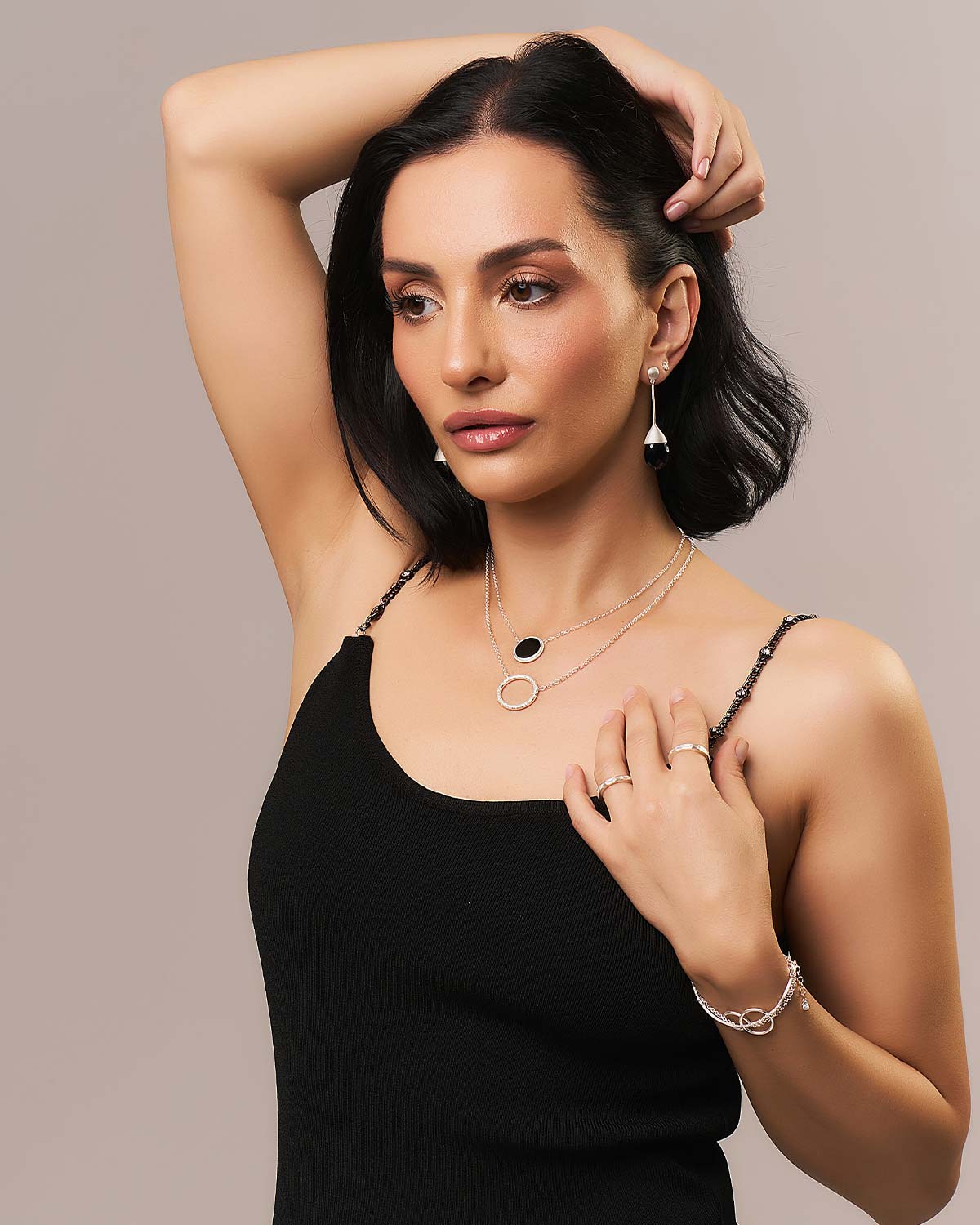 Model wearing black spinel gemstone drop earrings with a polished gold finish