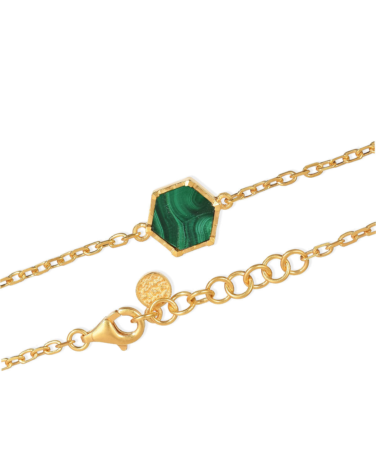 Close-up of a gold and silver bracelet with a natural malachite gemstone