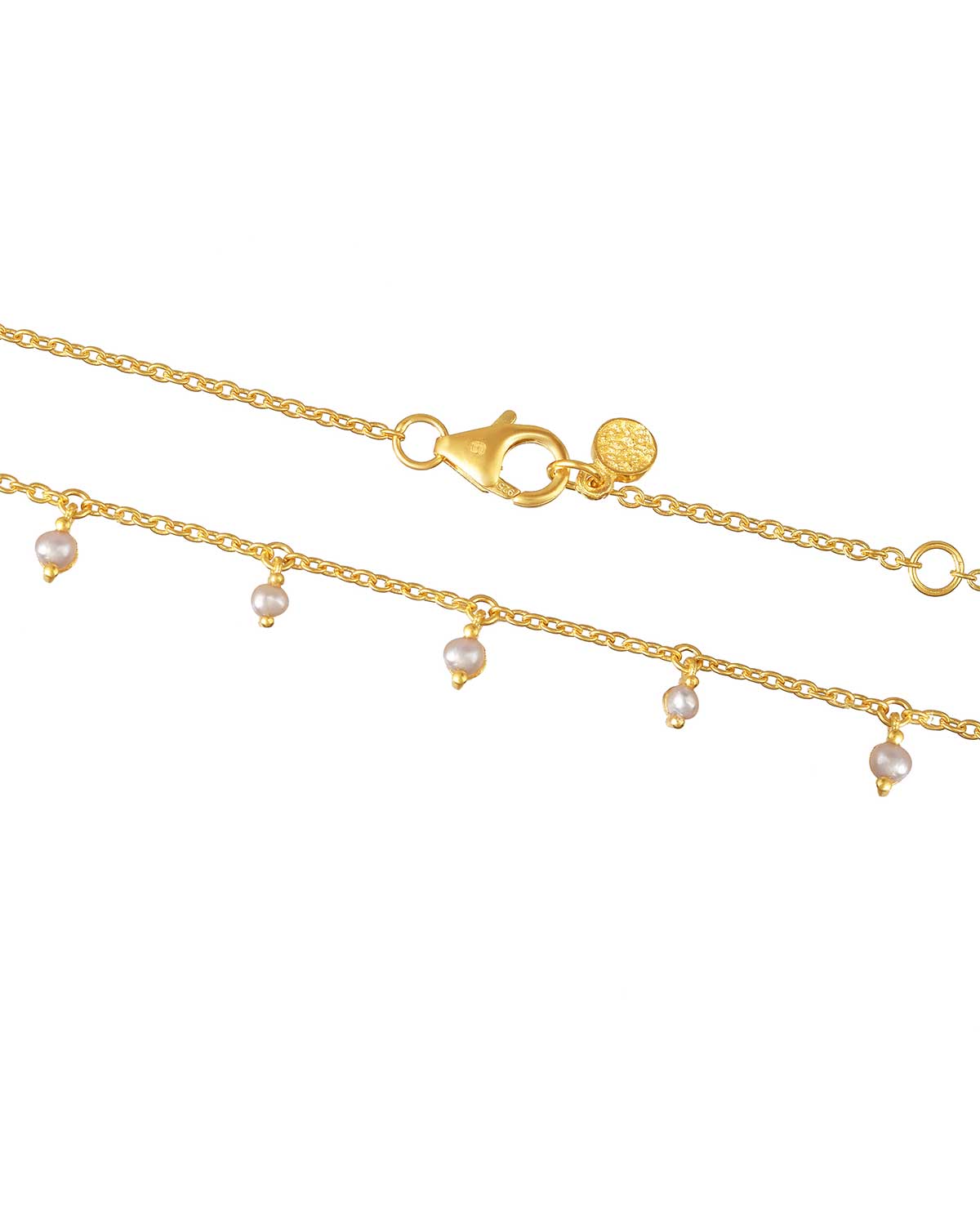 Detailed view of pearls on a gold necklace with smooth finish