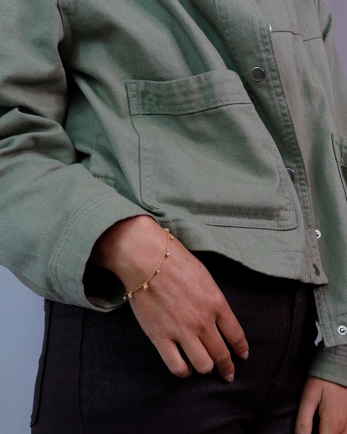 Model wearing silver bracelet with elegant pearl detailing