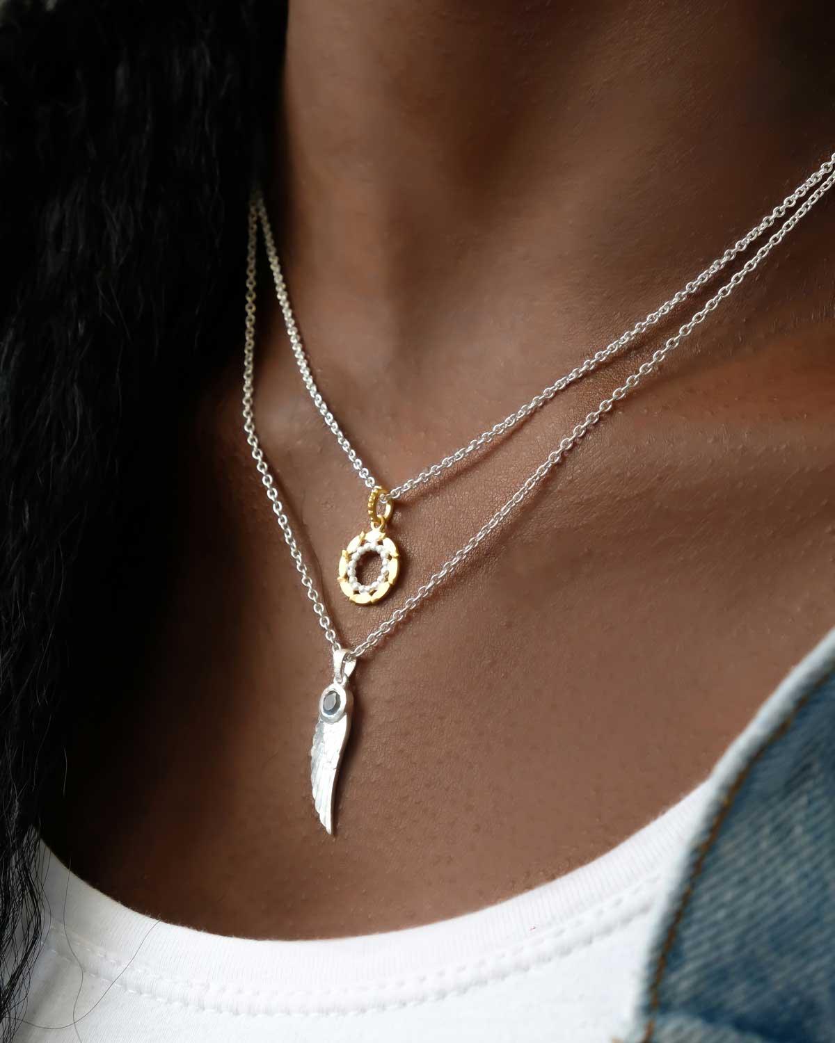 Model wearing silver angel wing necklace with natural gemstone