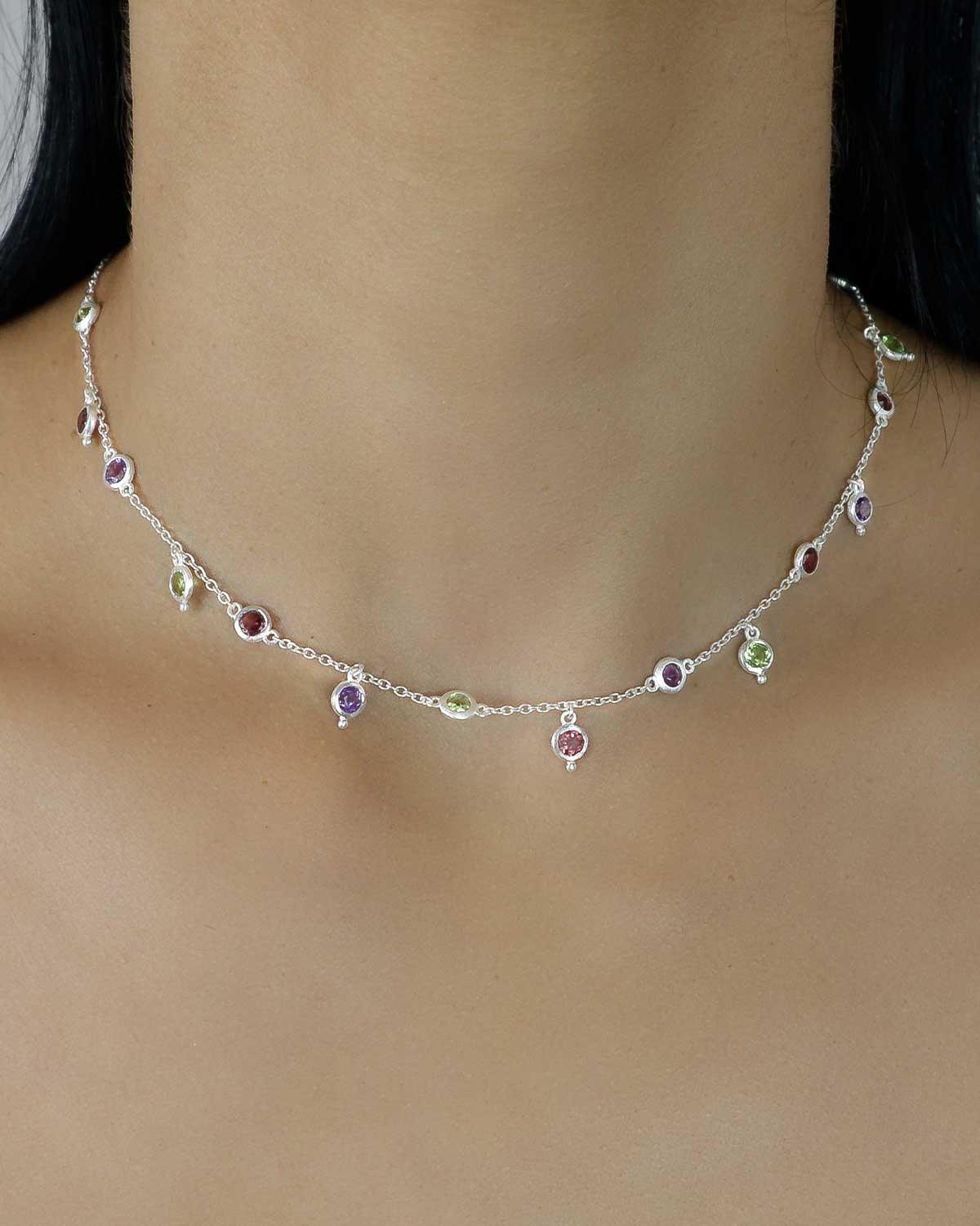 Close-up of silver necklace with mixed gemstone details and polished finish