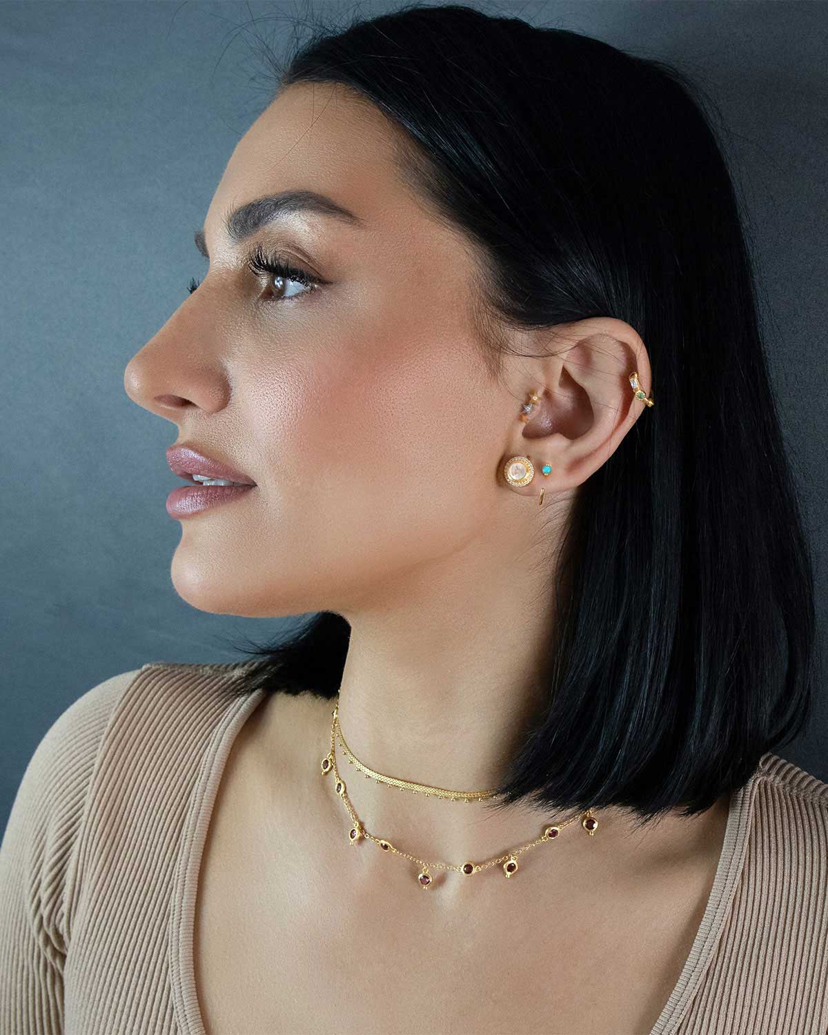 Model wearing gold necklace with rhodolite garnet gemstones